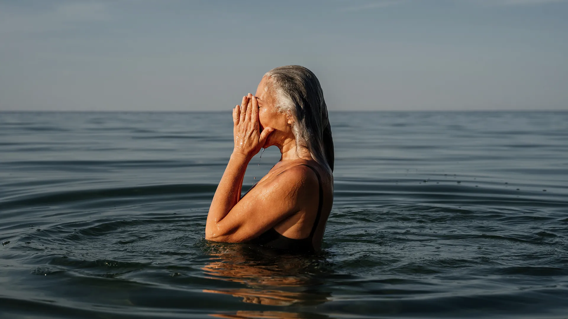 Woman emerging from the ocean, representing strength, vitality, renewal, and a proactive approach to women’s health and healthy aging.
