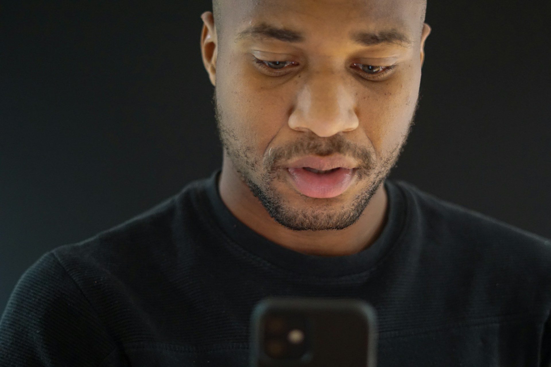 A close up of a man holding a phone