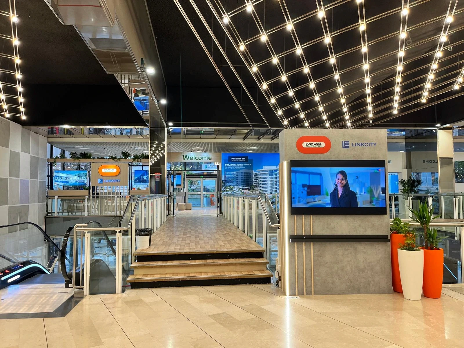 Stand Bouygues Construction & Linkcity conçu et réalisé par Expace au MIPIM Cannes 2026 – espace sur-mesure sur la Croisette avec accueil signature, lounge, écrans projets immobiliers et terrasse végétalisée.