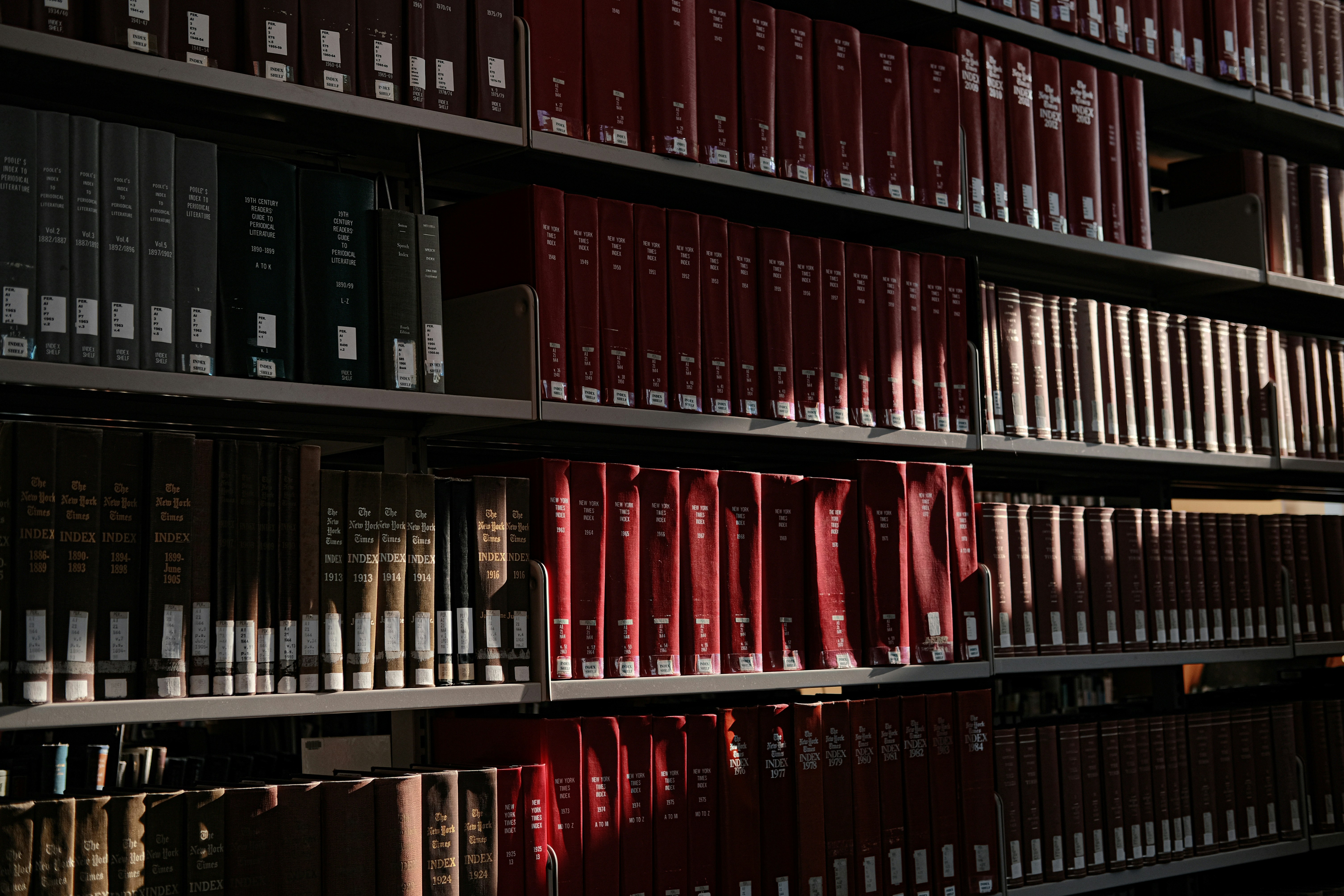 Books fill shelves in a well-lit library.