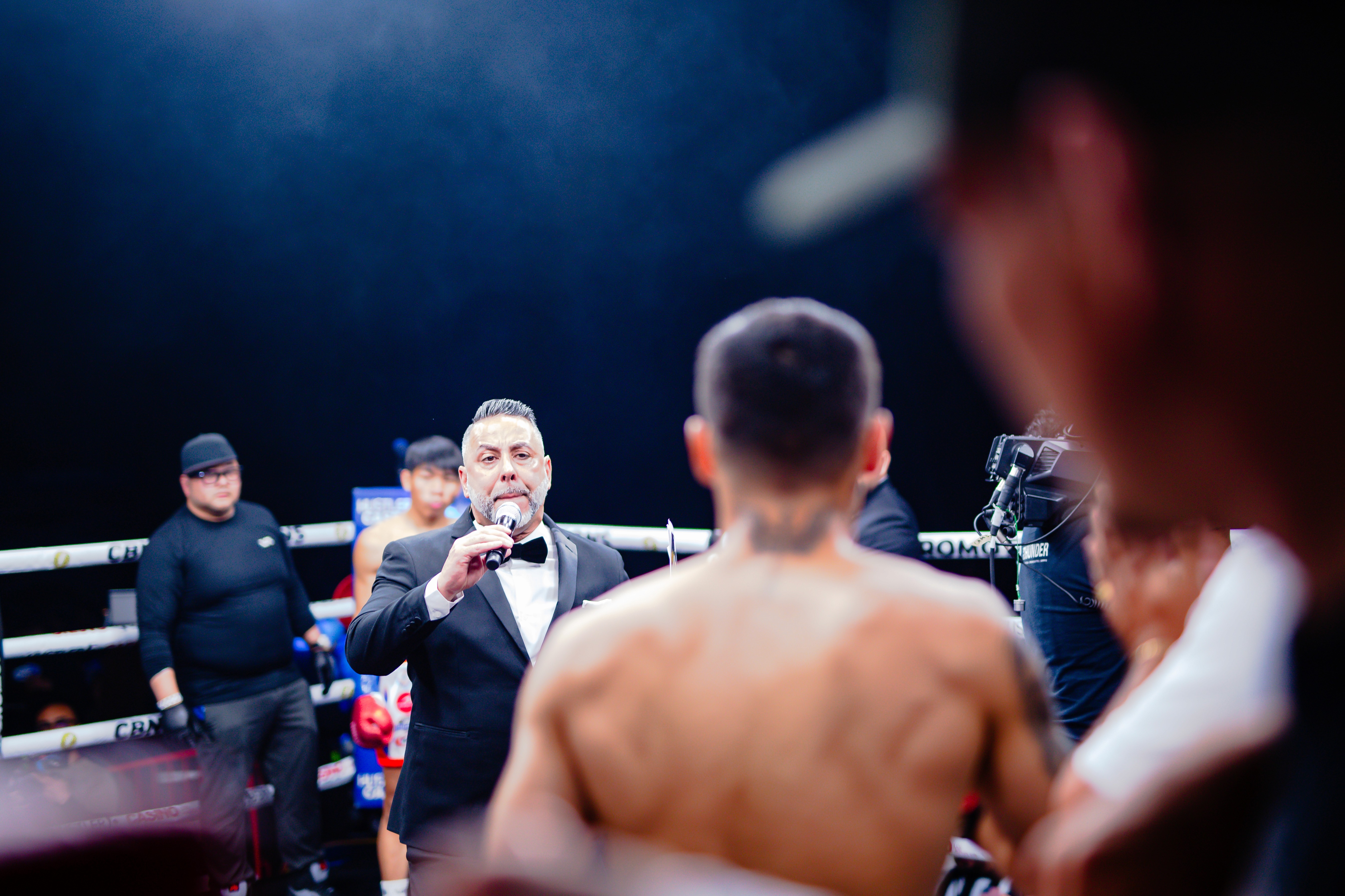 Jesús Soto Karass standing in George "El Phantasma" Navarro corner as the announcer introduces both fighters and the opponent waits in the background. 