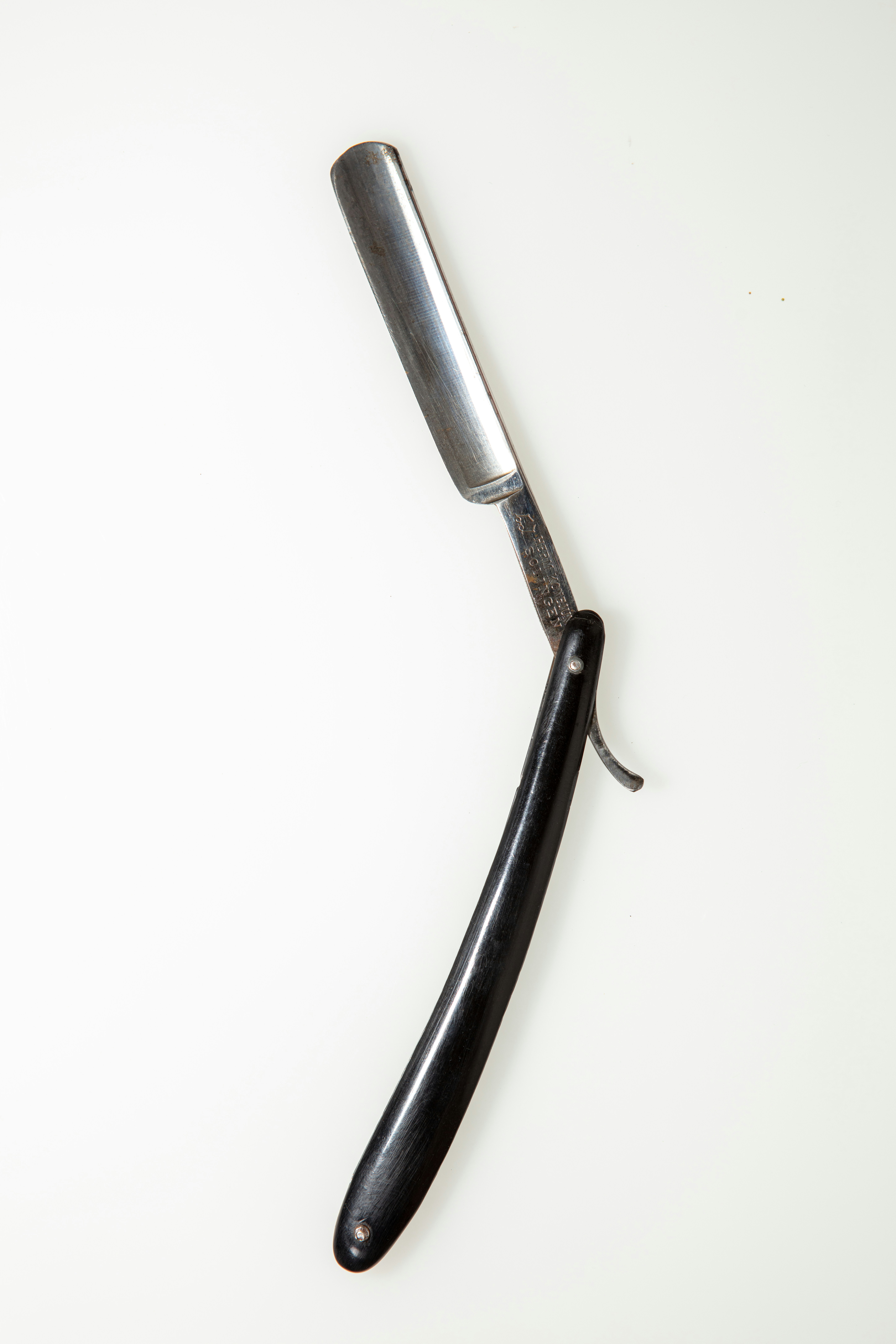 A knife with a black handle on a white background