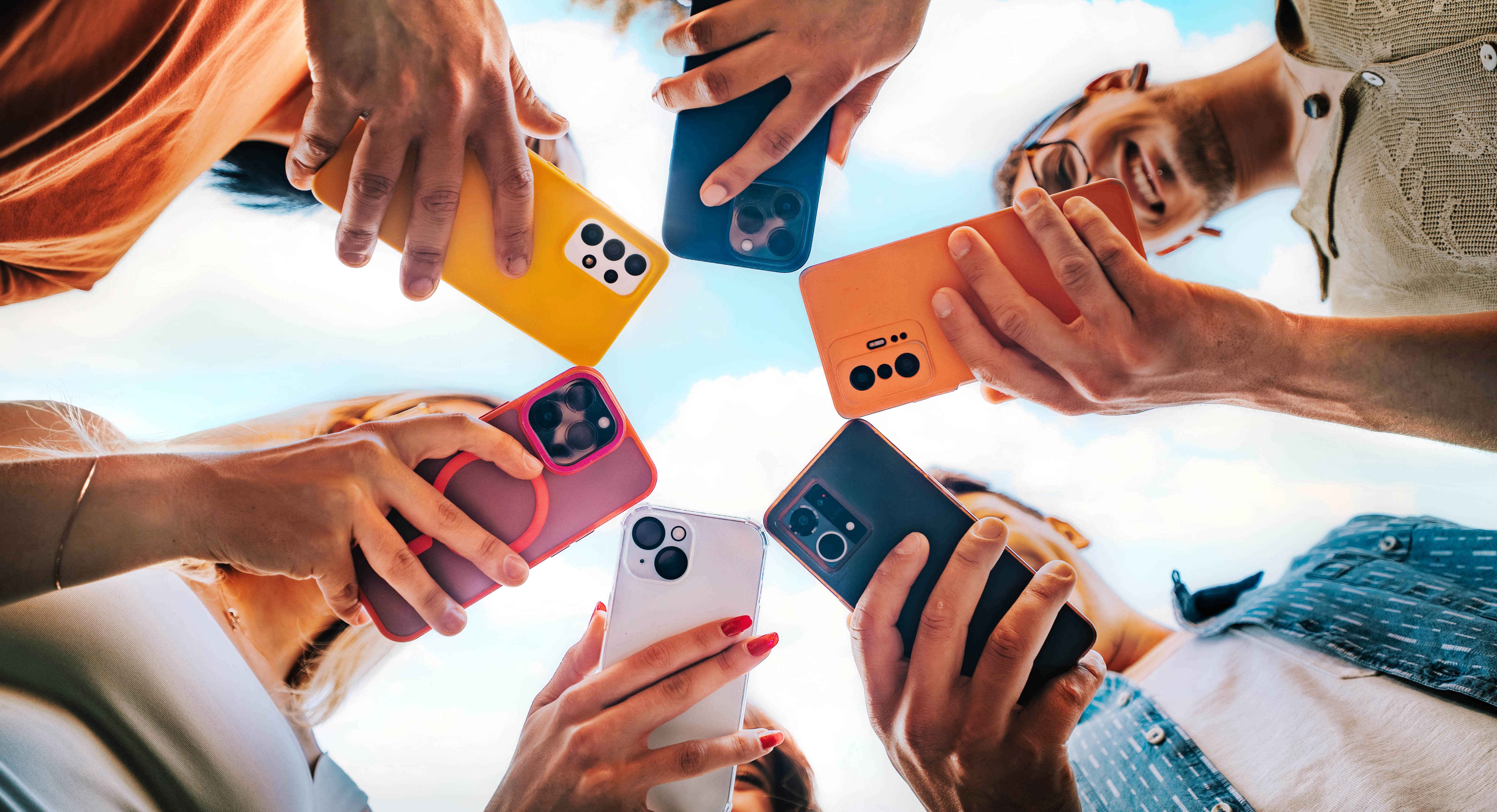 Pessoas segurando smartphones modernos em círculo, representando troca de celular e planejamento de compra como no consórcio de celular.