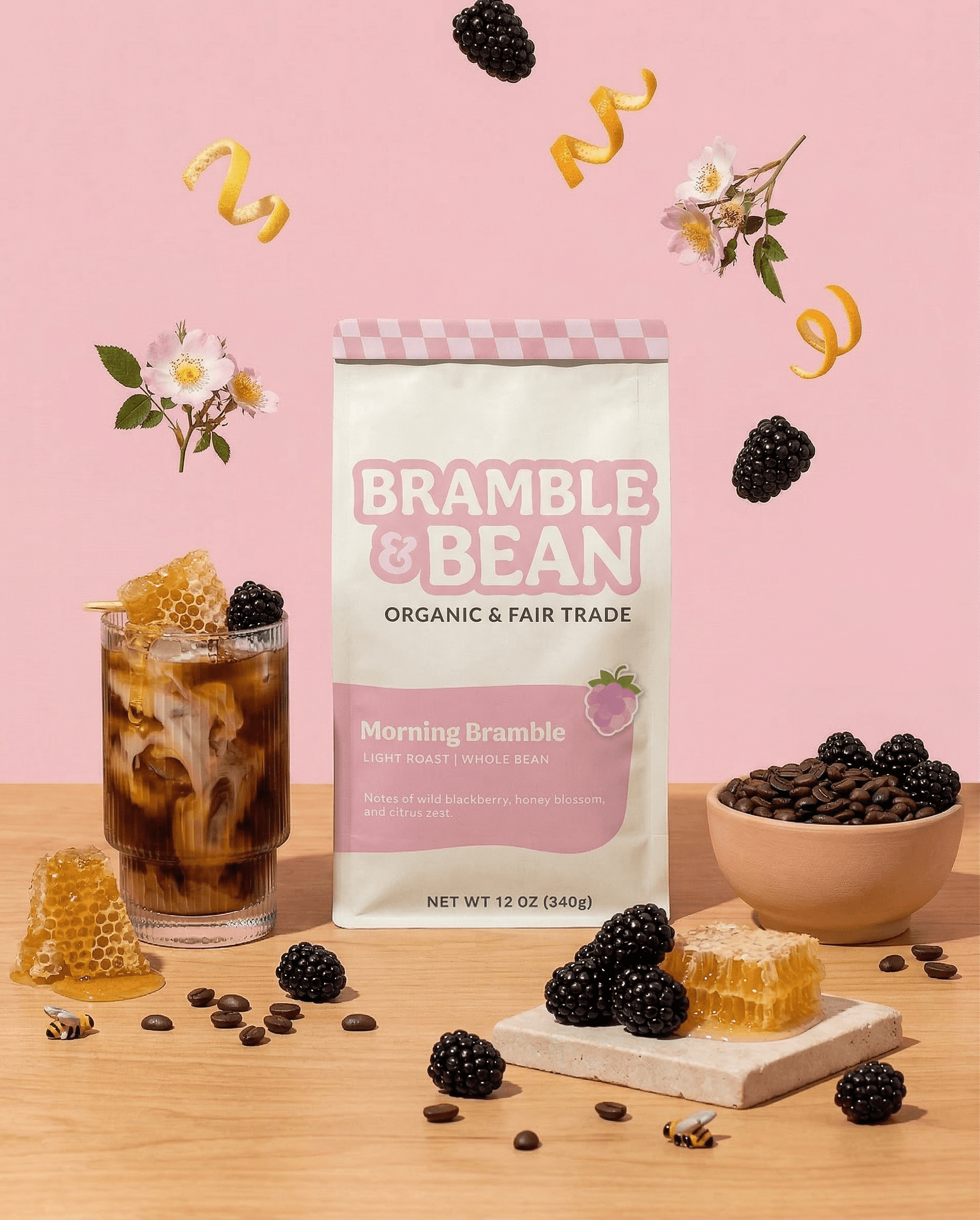 Bramble & bean coffee packaging surrounded by a bowl of coffee beans on the right and an iced coffee on the left.