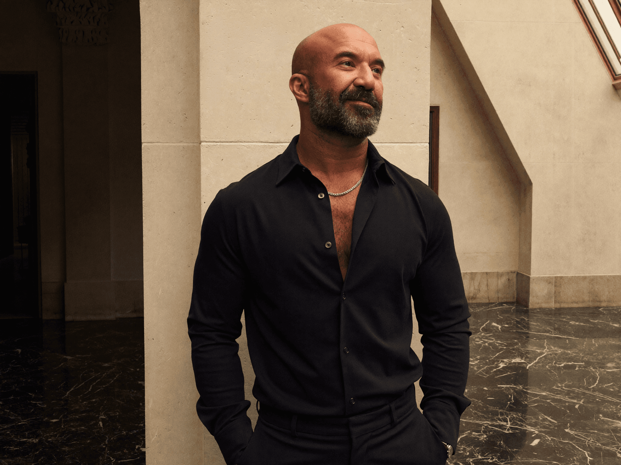 Borhan in a black shirt beside a stone column