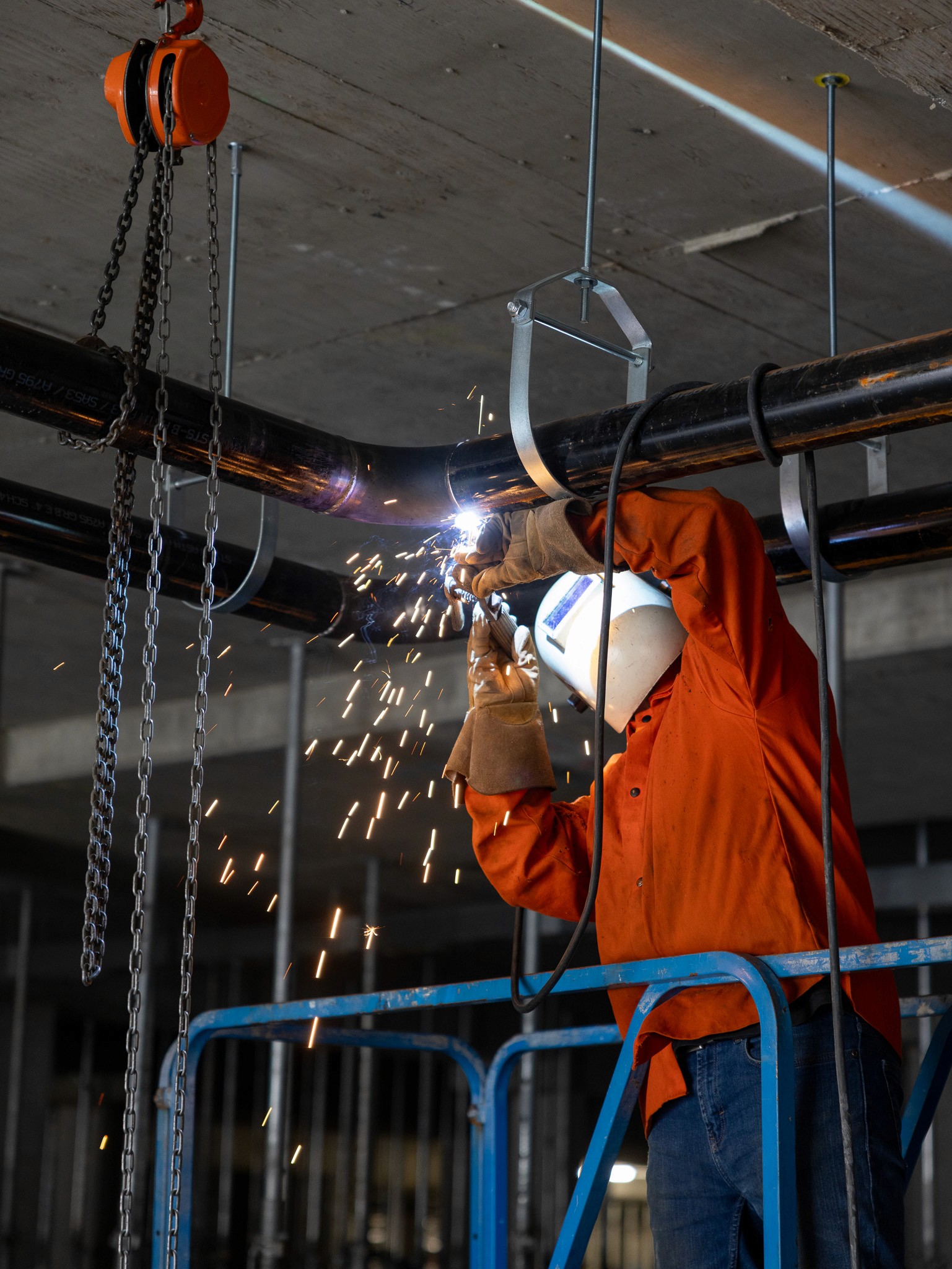 Worker in Chilliwack, British Columbia, welding pipes for HVAC and plumbing in Andmar
