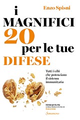 A young person with curly hair smiles at the camera while sitting in front of a laptop against a dark background.