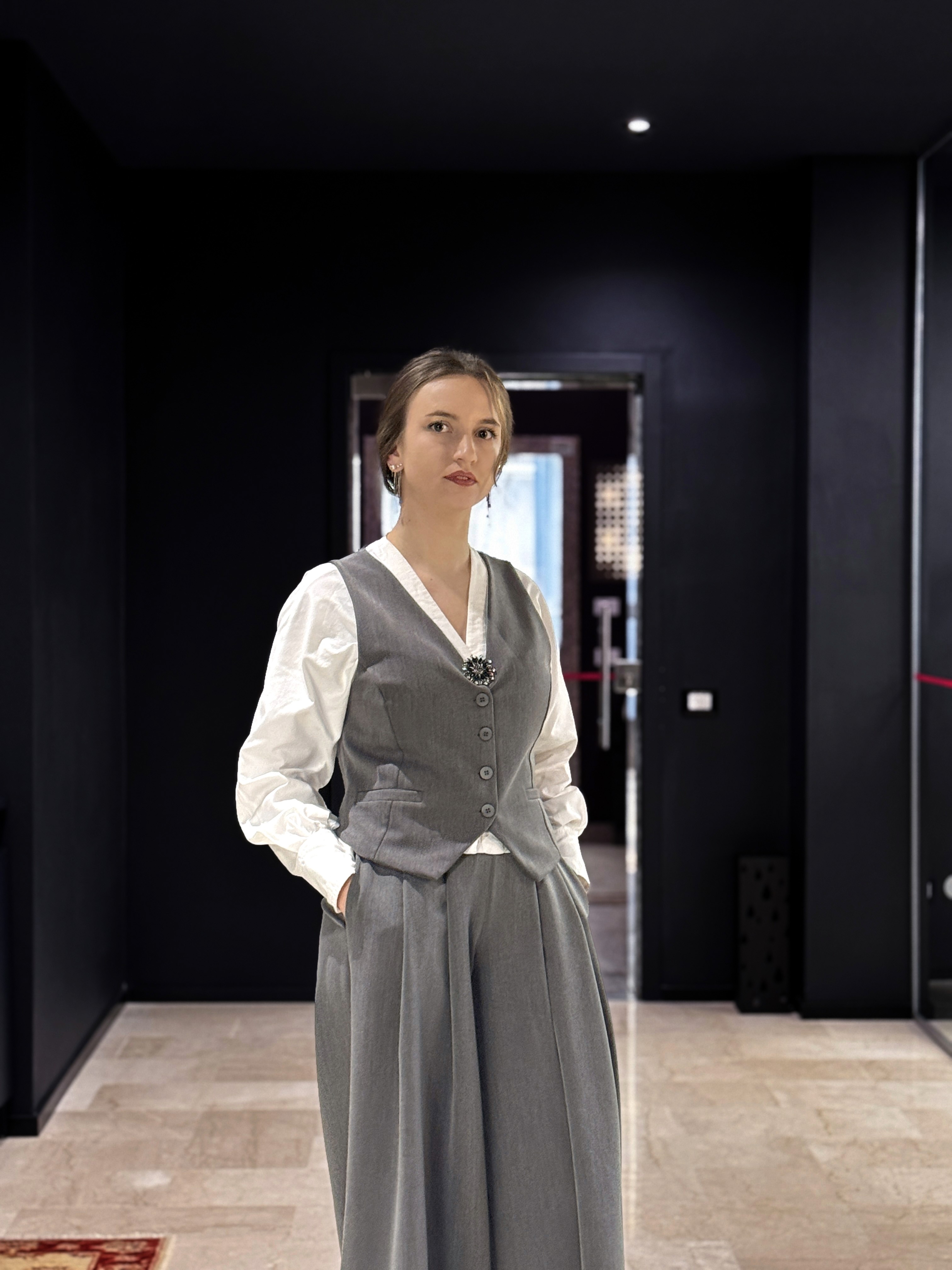 woman wearing white dress shirt using holding black leather case on brown wooden table
