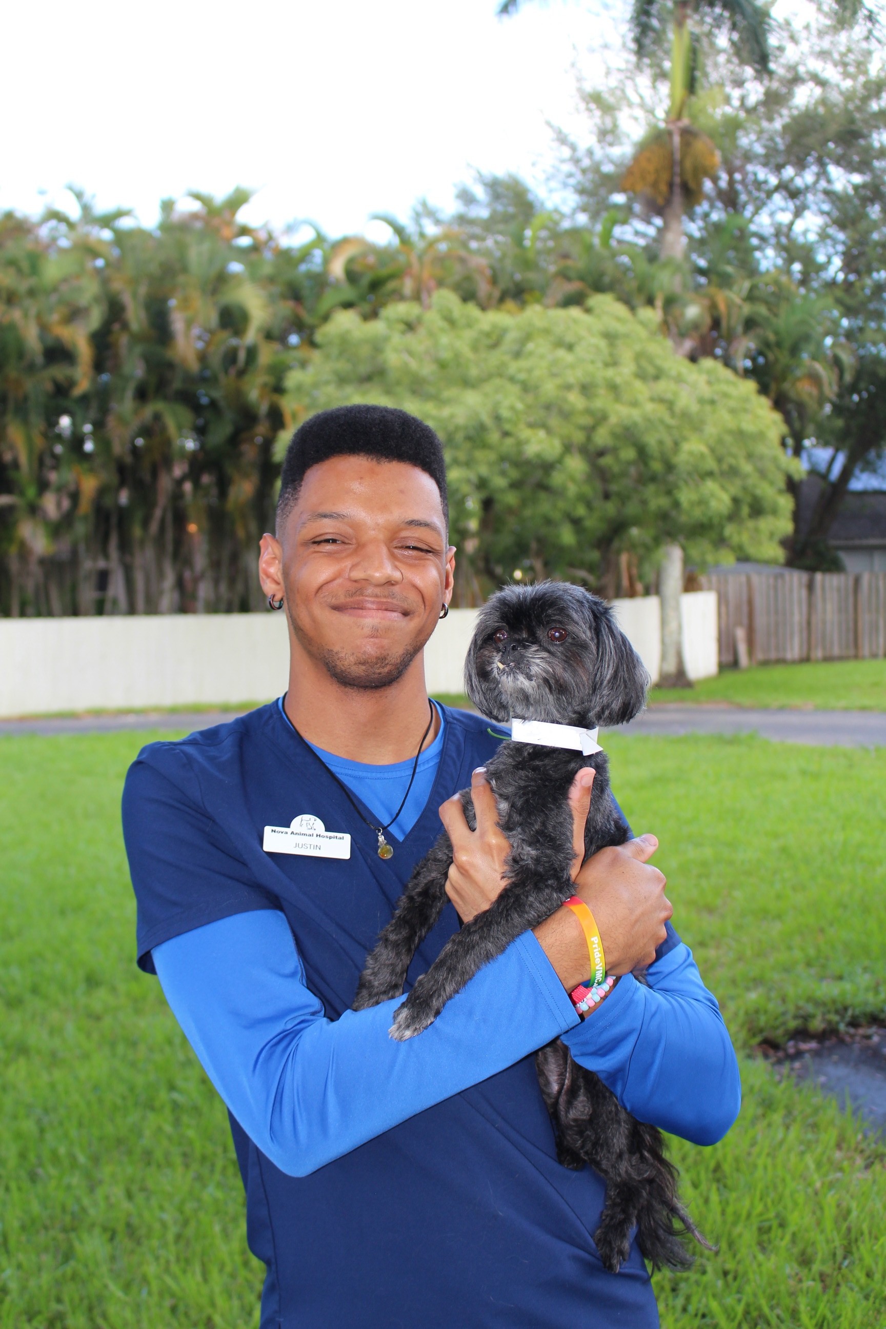 justin holding a small black Affenpinscher outside