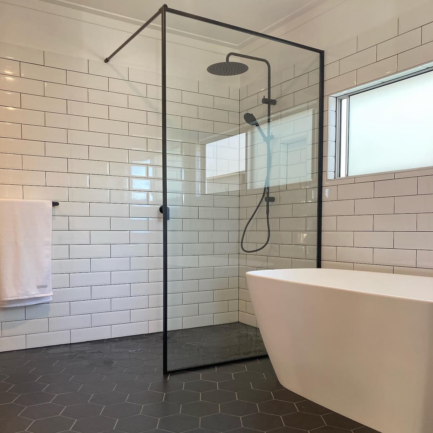 Modern bathroom renovation with glass shower and white subway tiles in Brisbane.