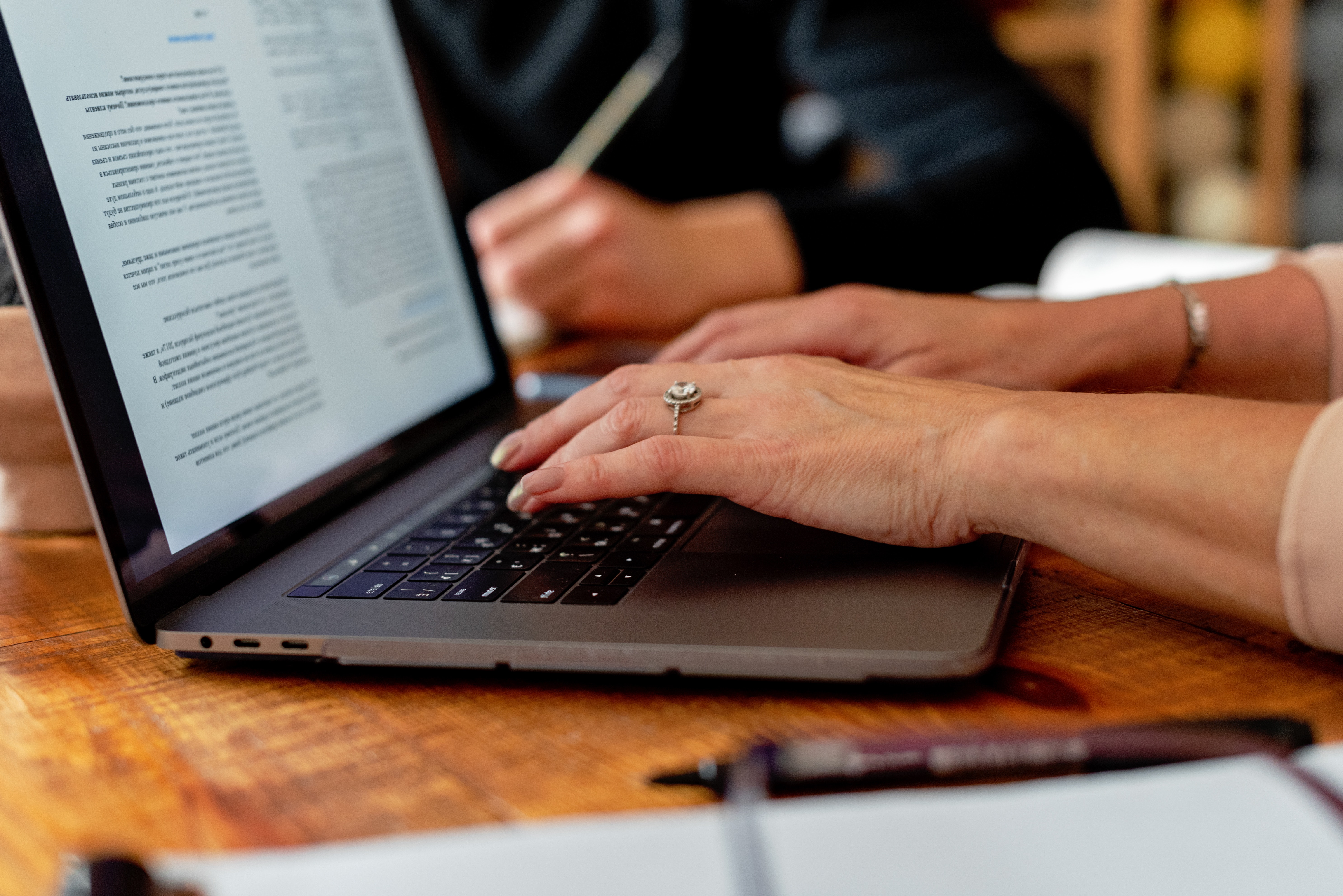 A person typing on a laptop computer, focused and engaged in their work