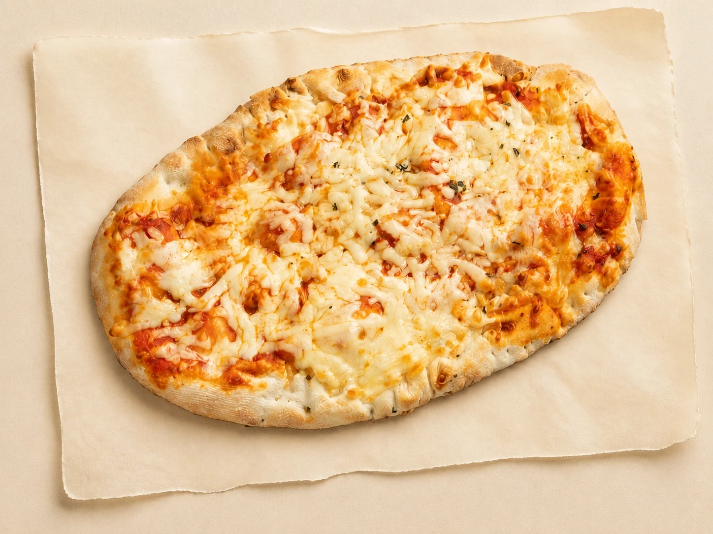 Ovale Pala van Mangia Bene met tomatensaus en gesmolten kaas, op bakpapier