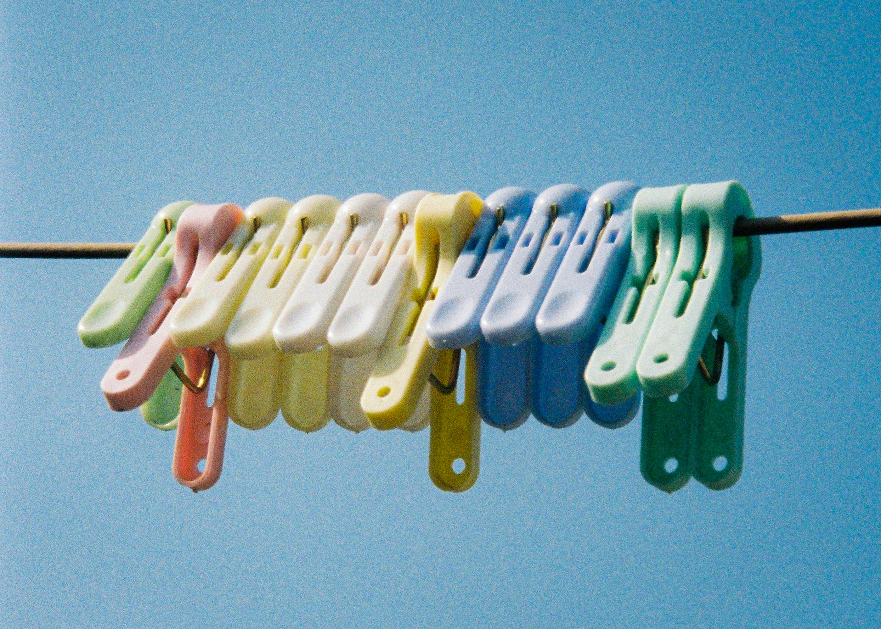 Colourful plastic clothespegs on a washing line — Eclo care guides