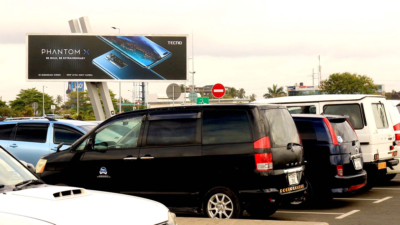 Minimalist pavilion with a perforated roof casting shadows on the white courtyard below.