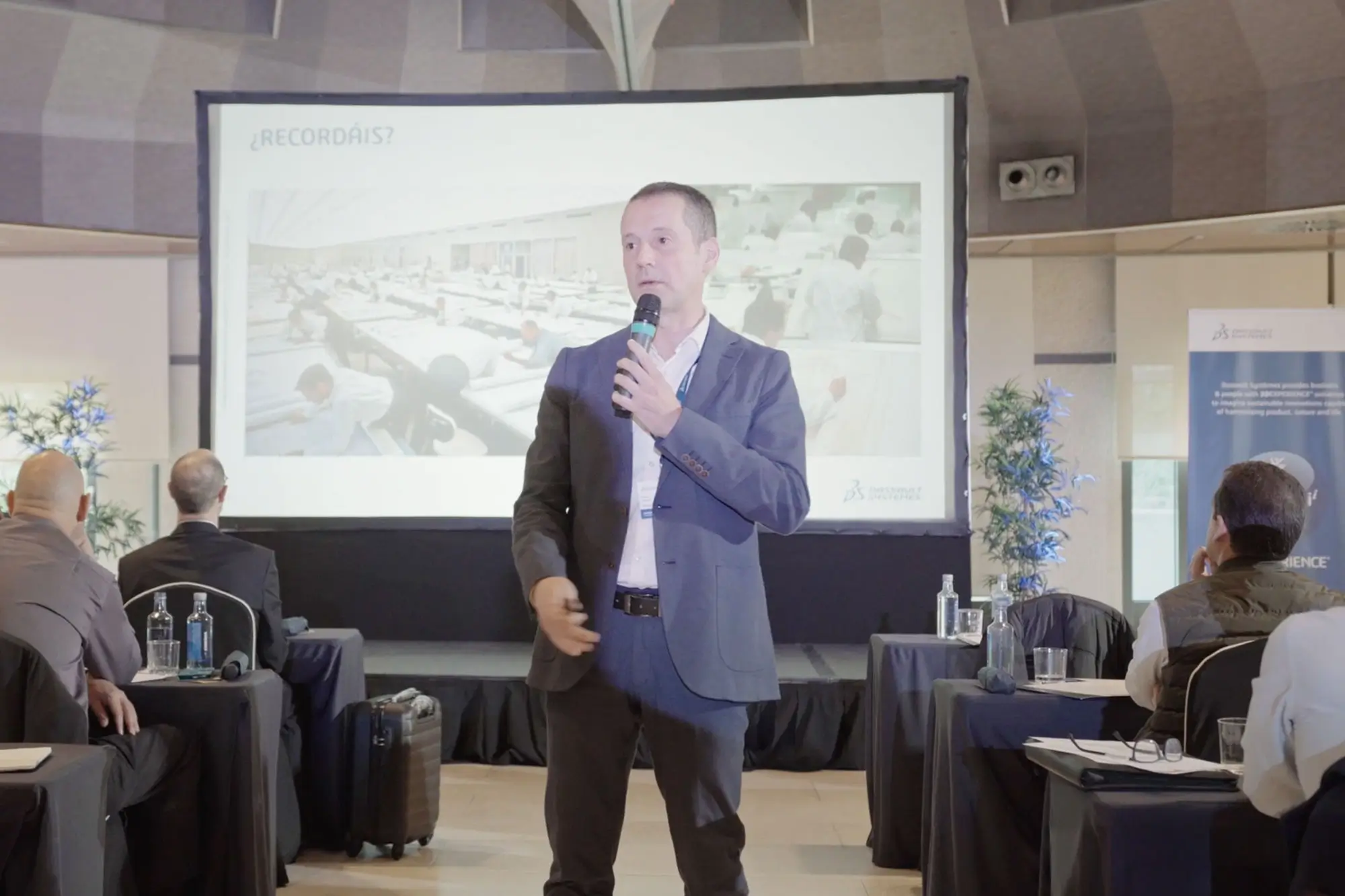 Portfolio Thankium: Conferencista en presentación empresarial con diapositiva en pantalla.