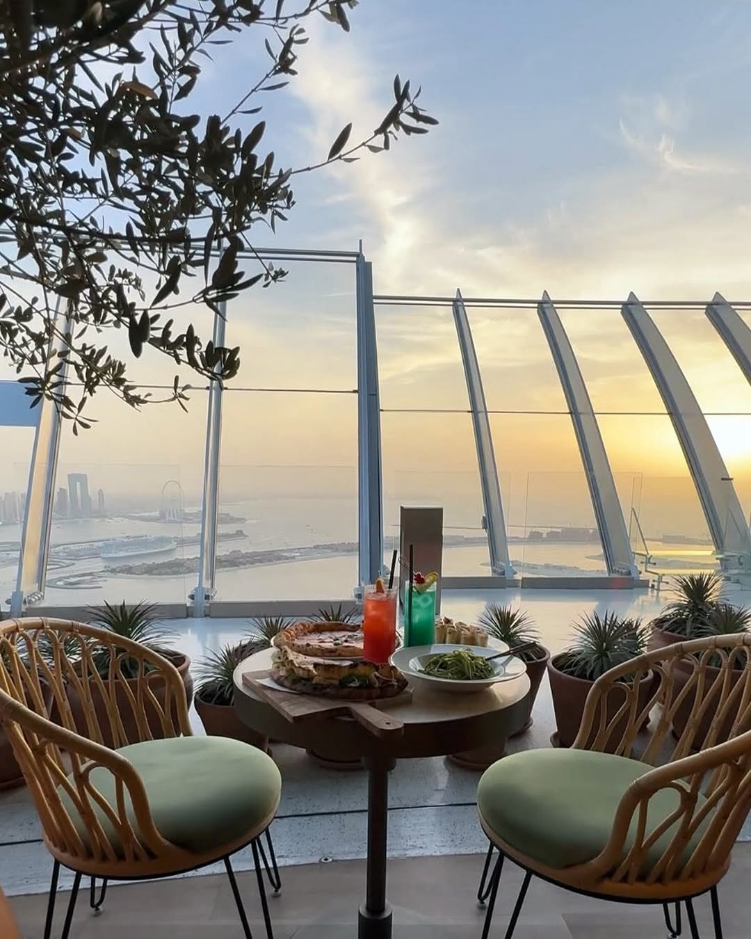 Two chairs and a table filled with food and drinks at The View Palm, with greenery on the sides, part of things to do in Dubai with family.