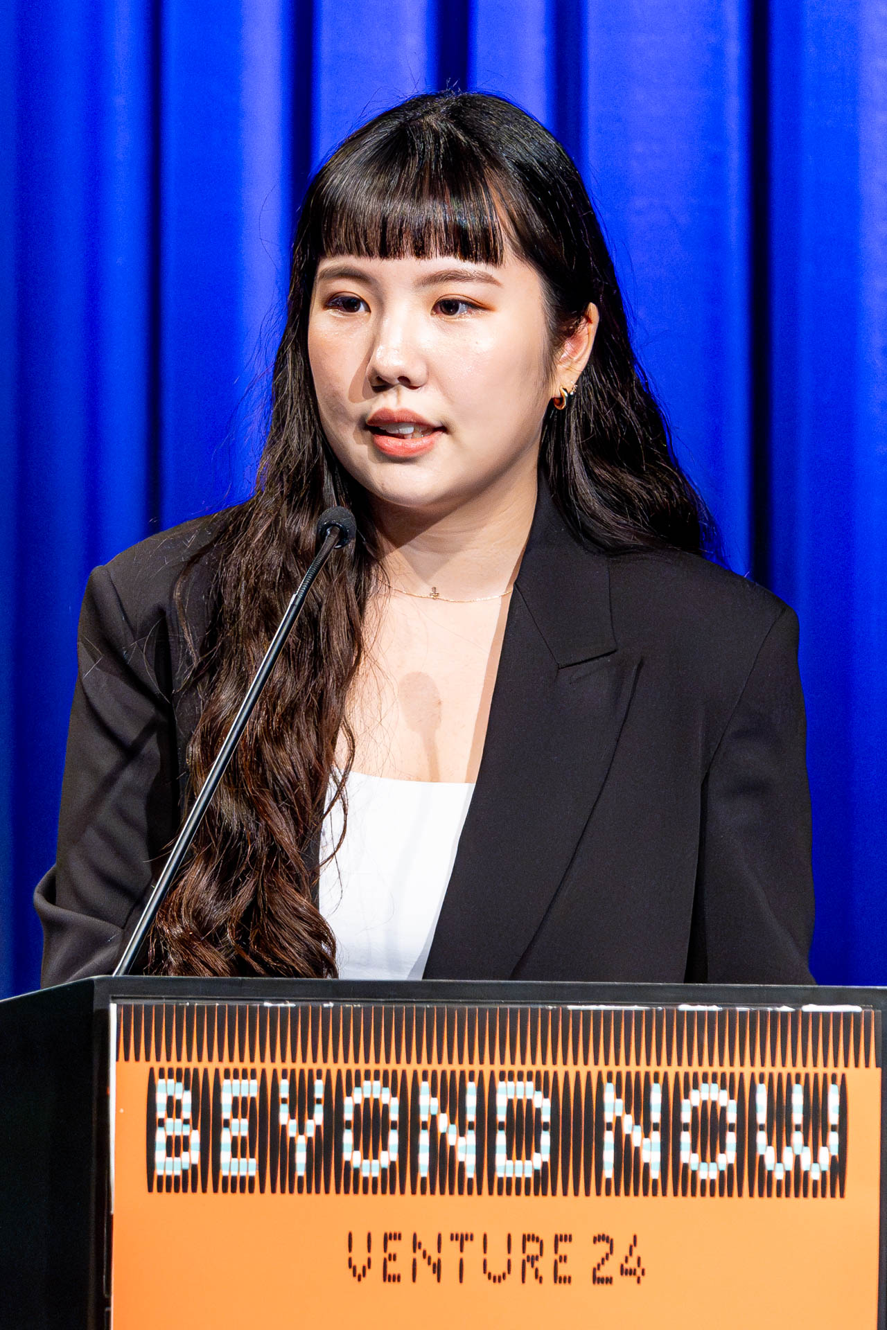 a student at a podium presenting a project in a Theatre