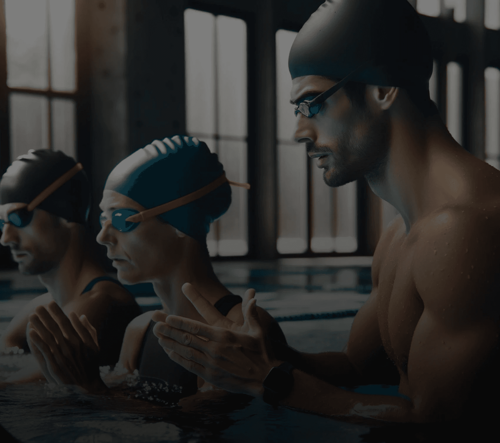 Deux nageurs et l'instructeur au premier plan dans une piscine intérieure