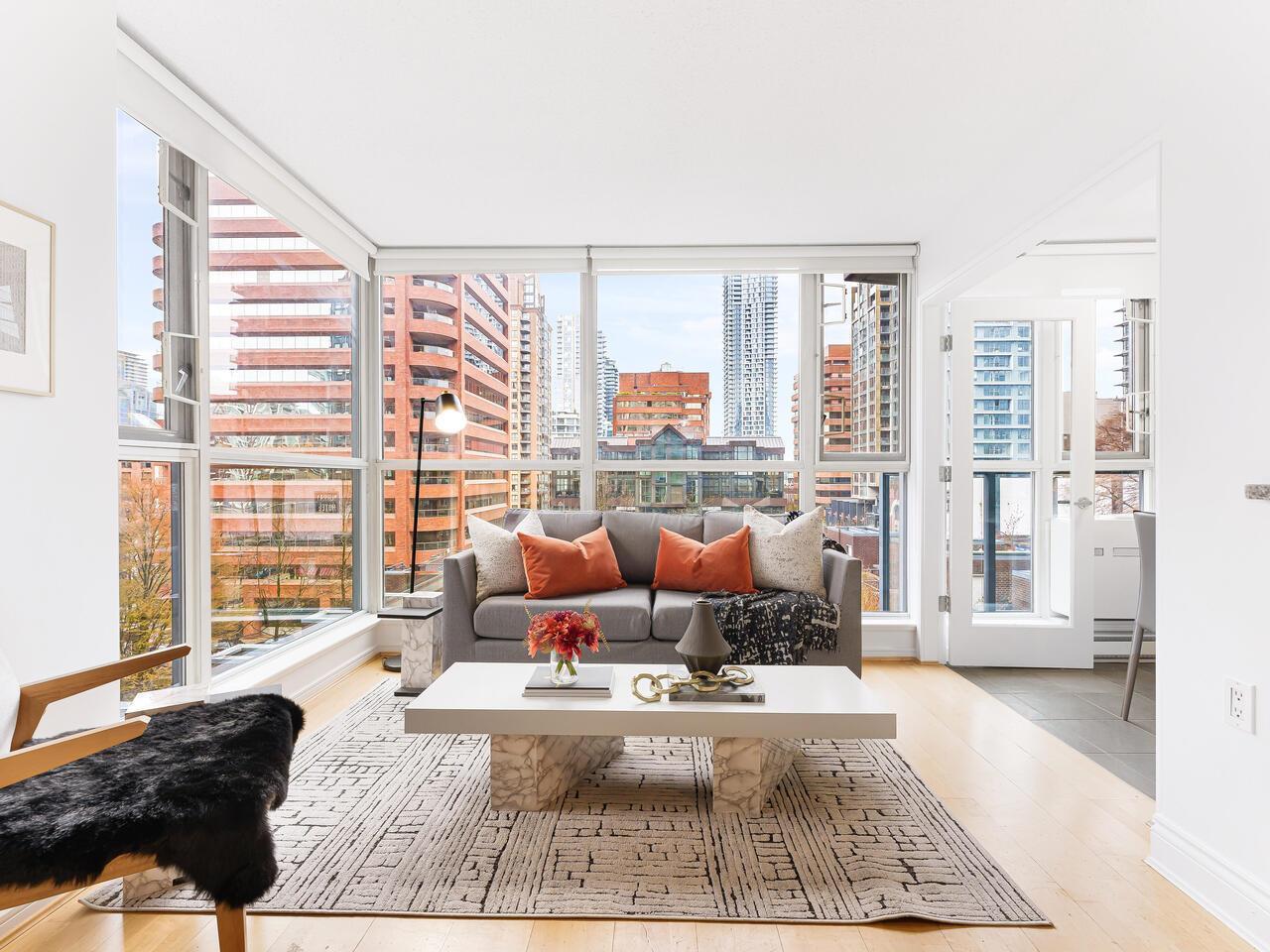 Bright, modern living room featuring a comfortable sofa, coffee table, and large windows with natural light.