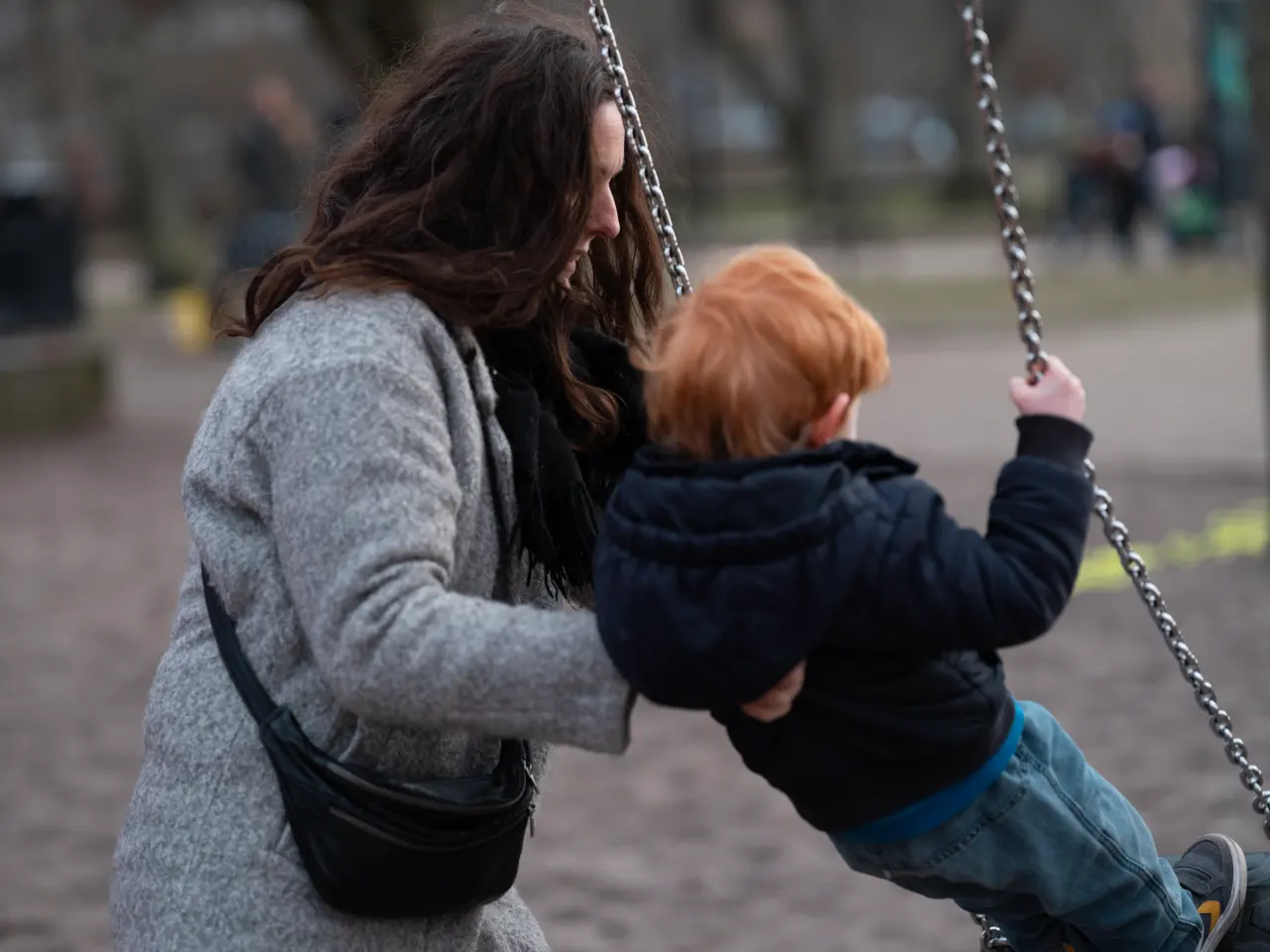 Mujer divorciada jugando con su hijo en el parque: qué seguros revisar tras un divorcio o una separación