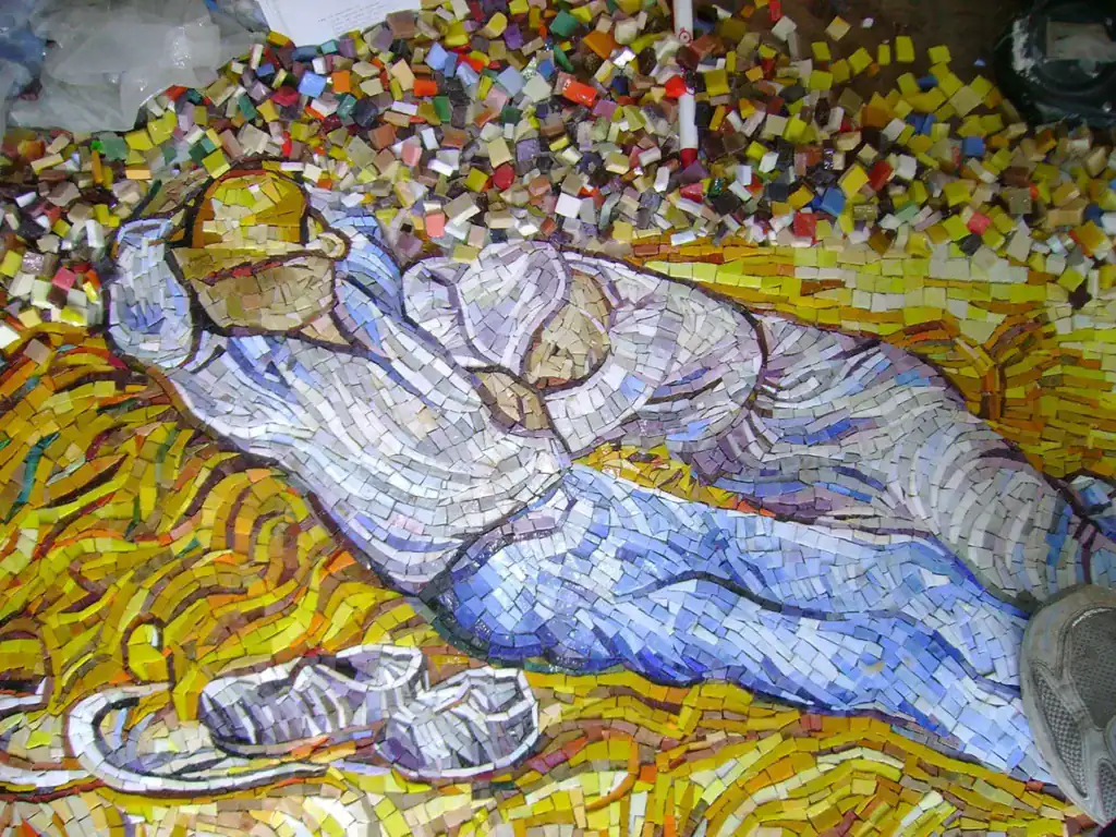 Mosaic art of a woman resting with a hat, inspired by Van Gogh's style.
