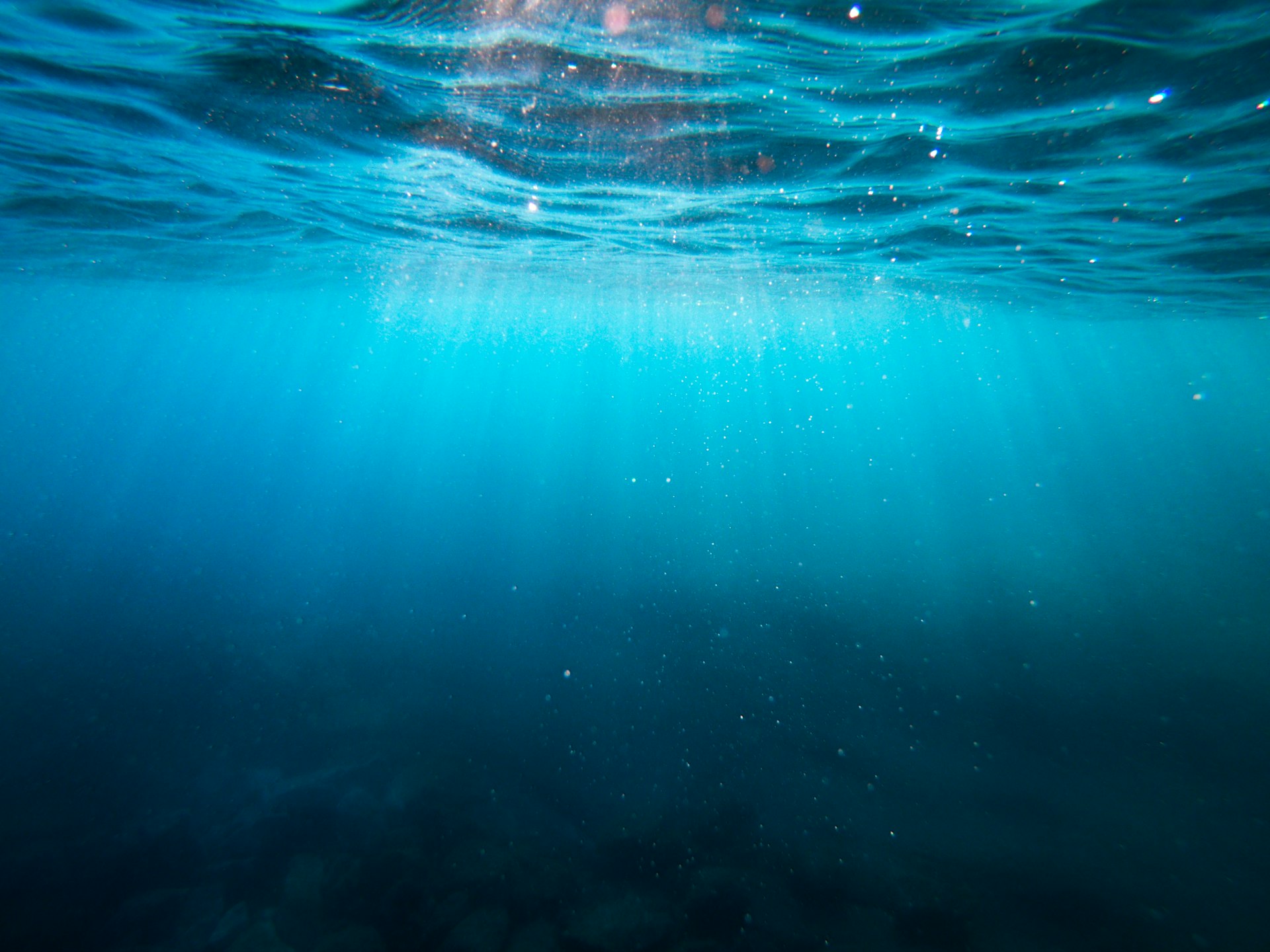 Sunlight breaking through the ocean surface underwater