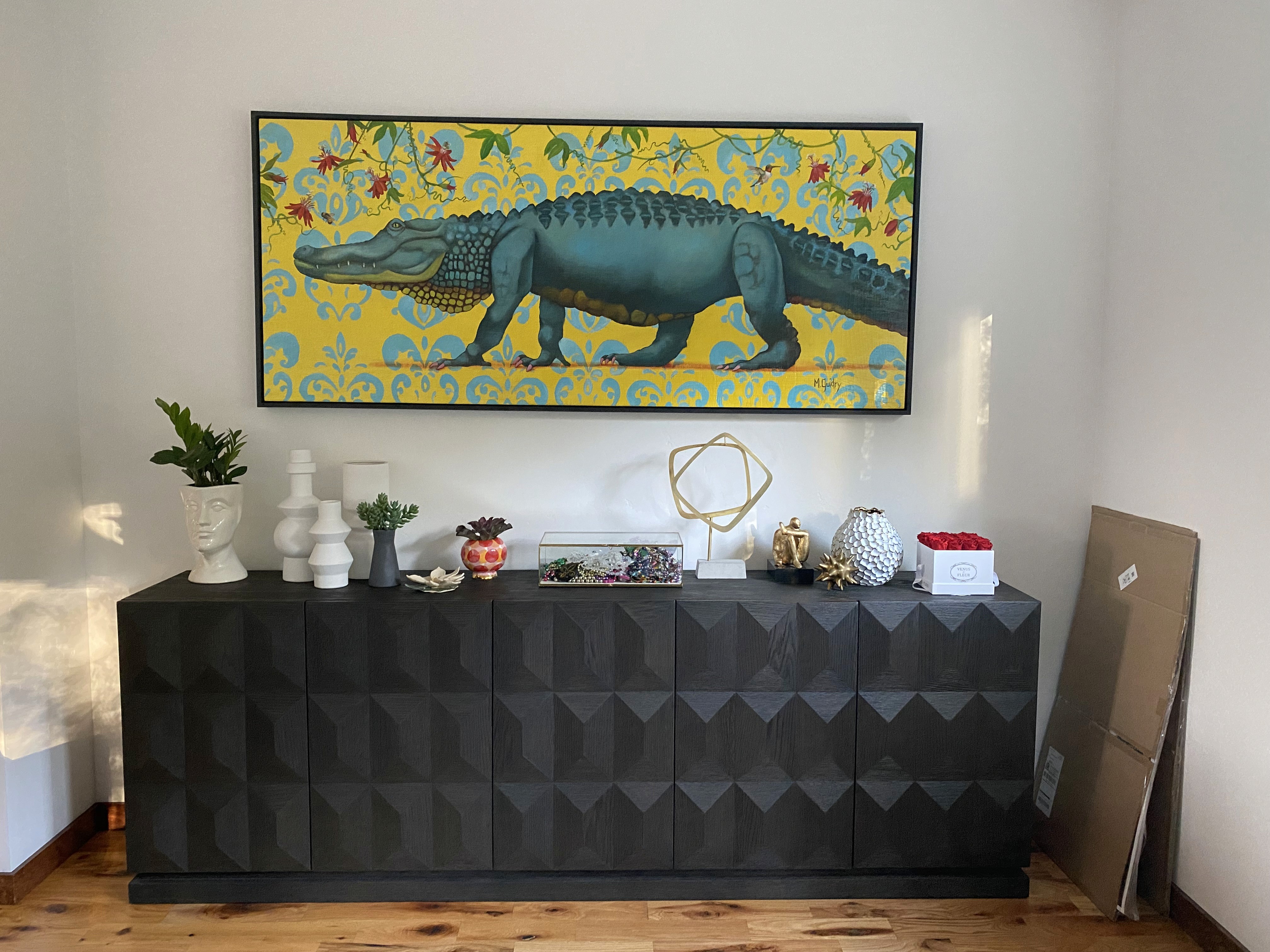 brown credenza with home decor and alligator painting