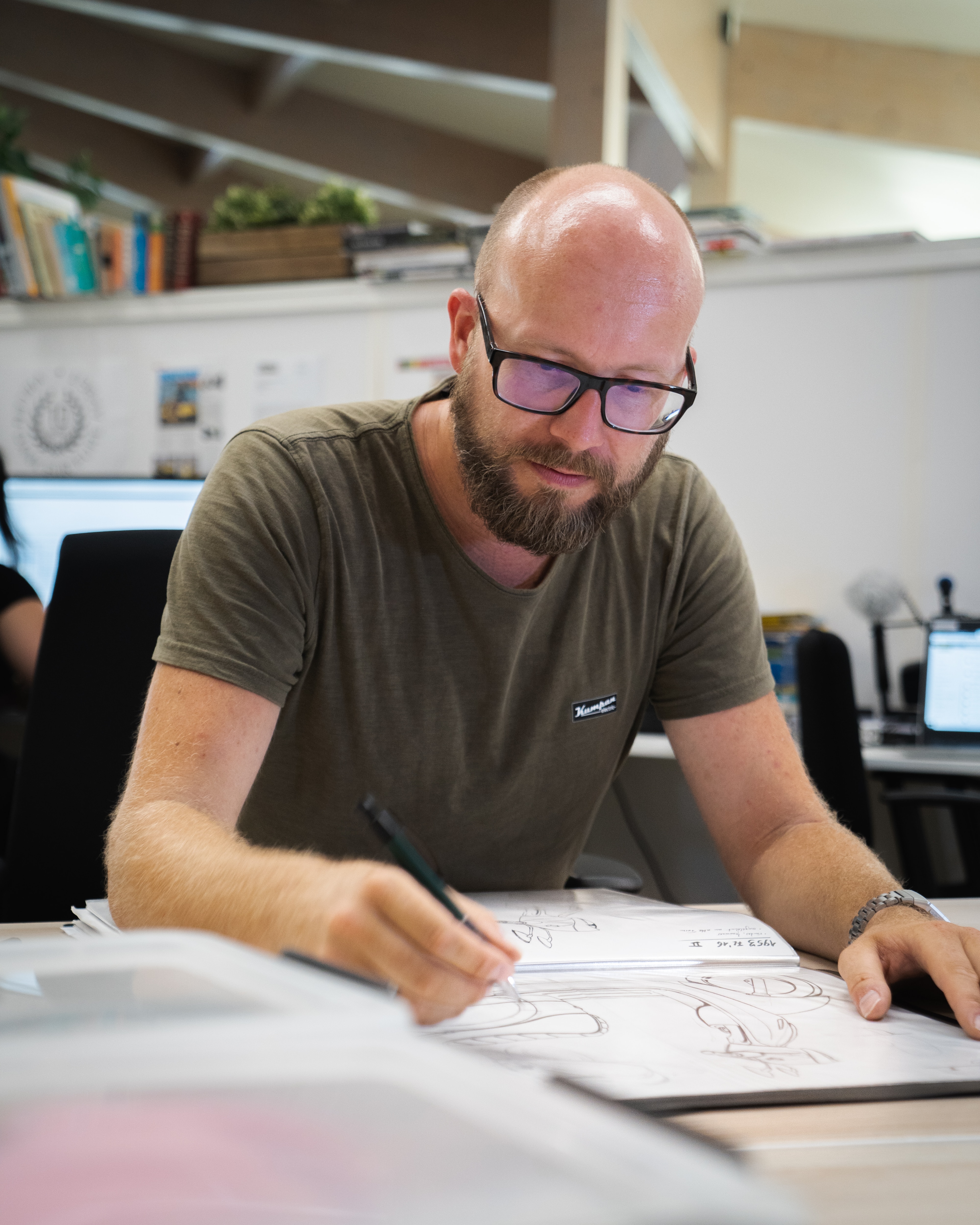 a man sitting at a desk writing on a piece of paper