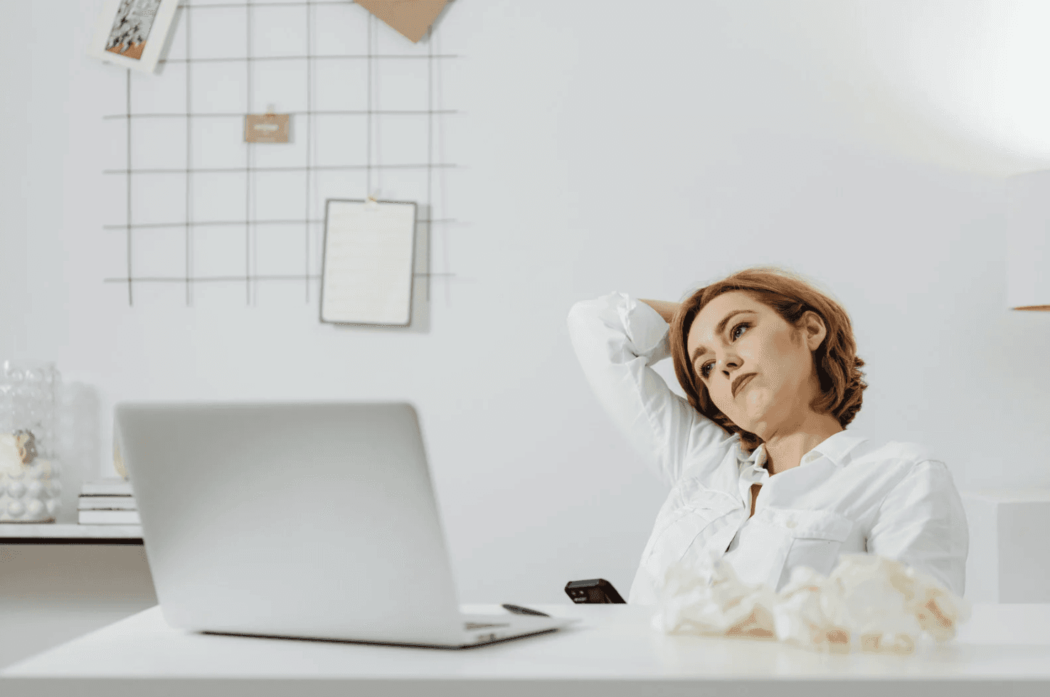 Business professional at desk looking thoughtful while working on laptop, representing advanced Amazon sellers re-evaluating PPC myths and outdated ad strategies.