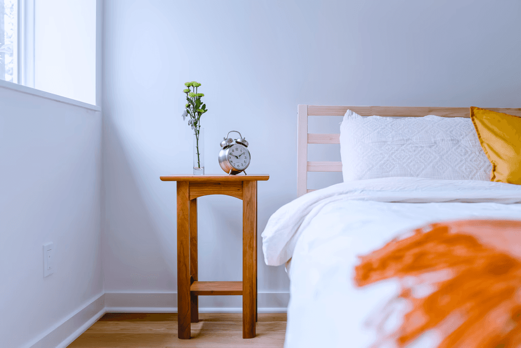brown wooden table with white and orange floral bed linen