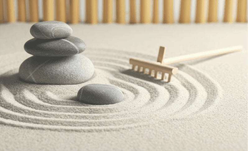 Raked sand and stacked stones, representing thoughtful program development and structured learning design.