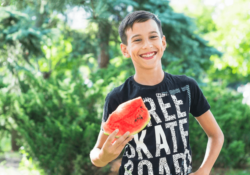 a group of people sitting around a table with laptops