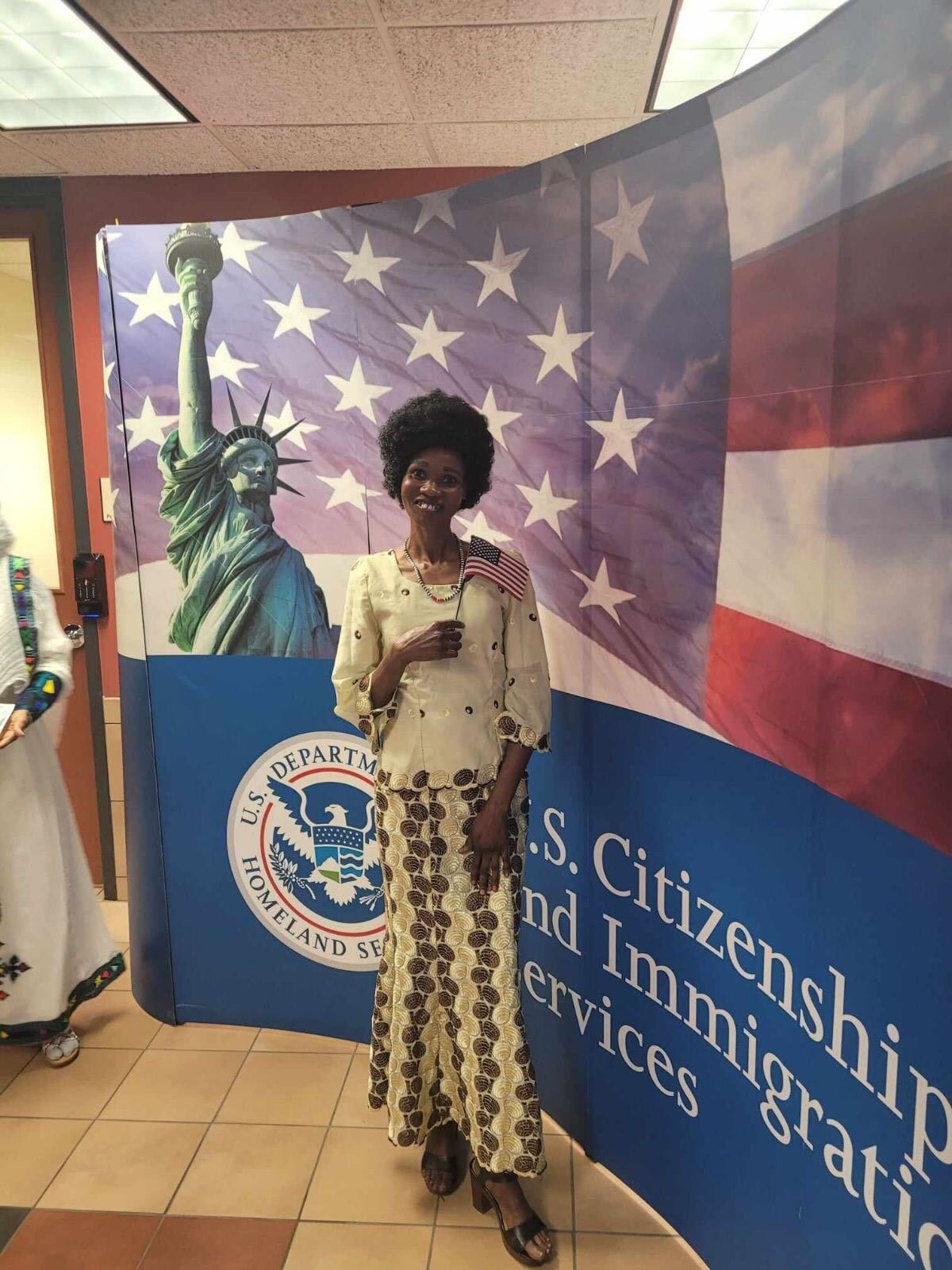 Ecstatic individual holding U.S. flag after naturalization, aided by Fibi Law