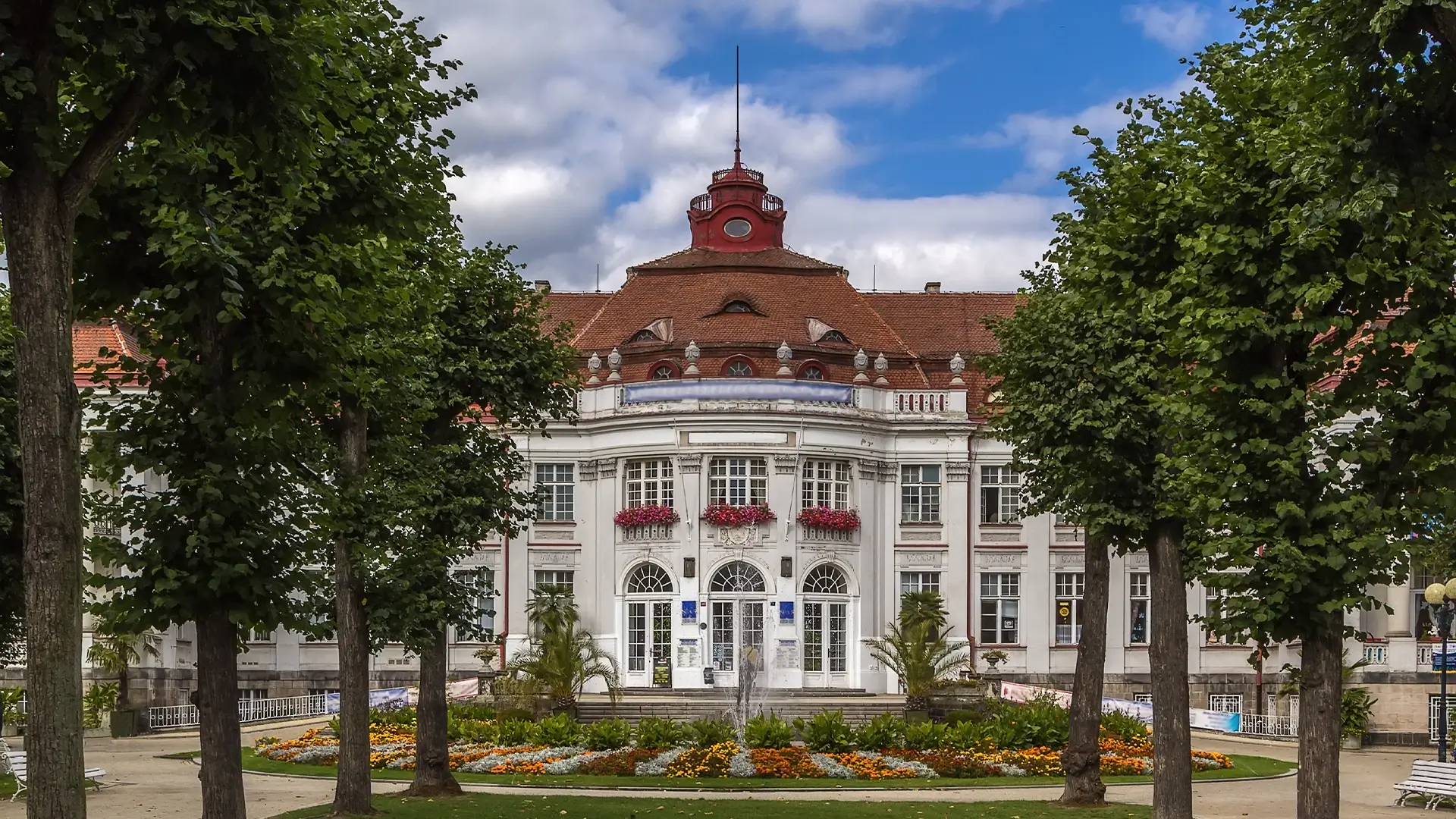 Historická budova lázní s fontánou. Turistická tvář města, která kontrastuje s realitou místních obyvatel.