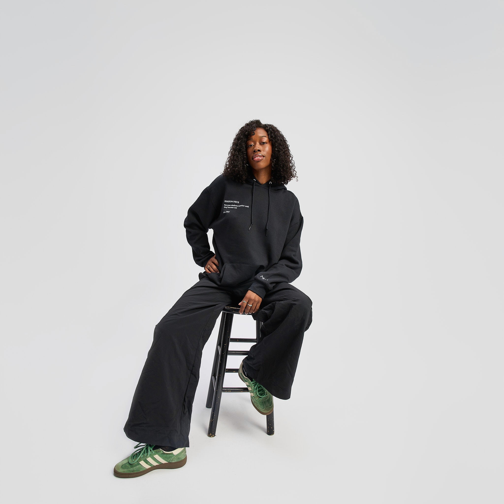 Young woman with dark hair and bangs, wearing red.