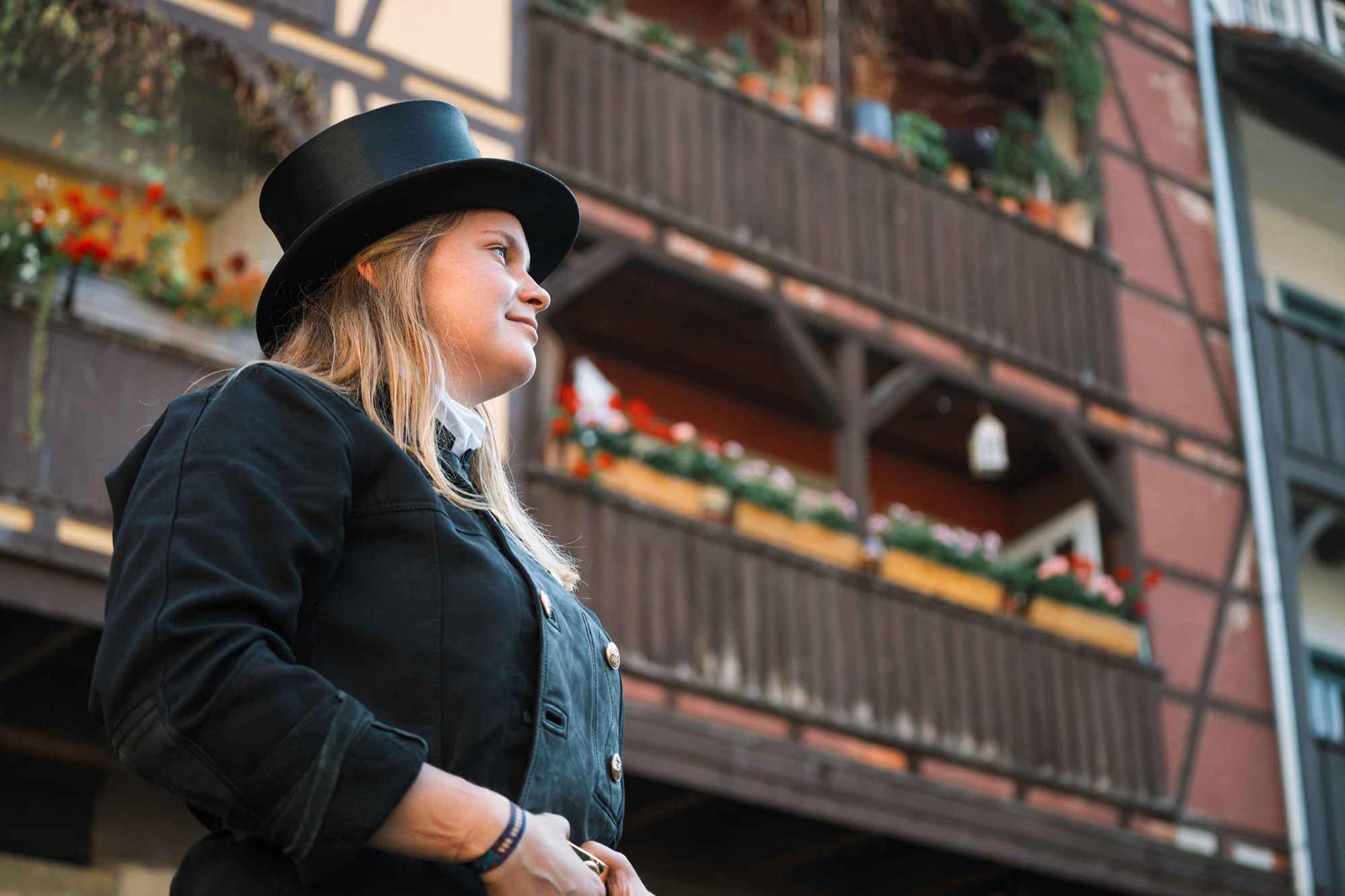 Chimney sweep in black coat, hat in front of rustic buildings. for Zentralverband-Deutscher-Schornsteinfeger