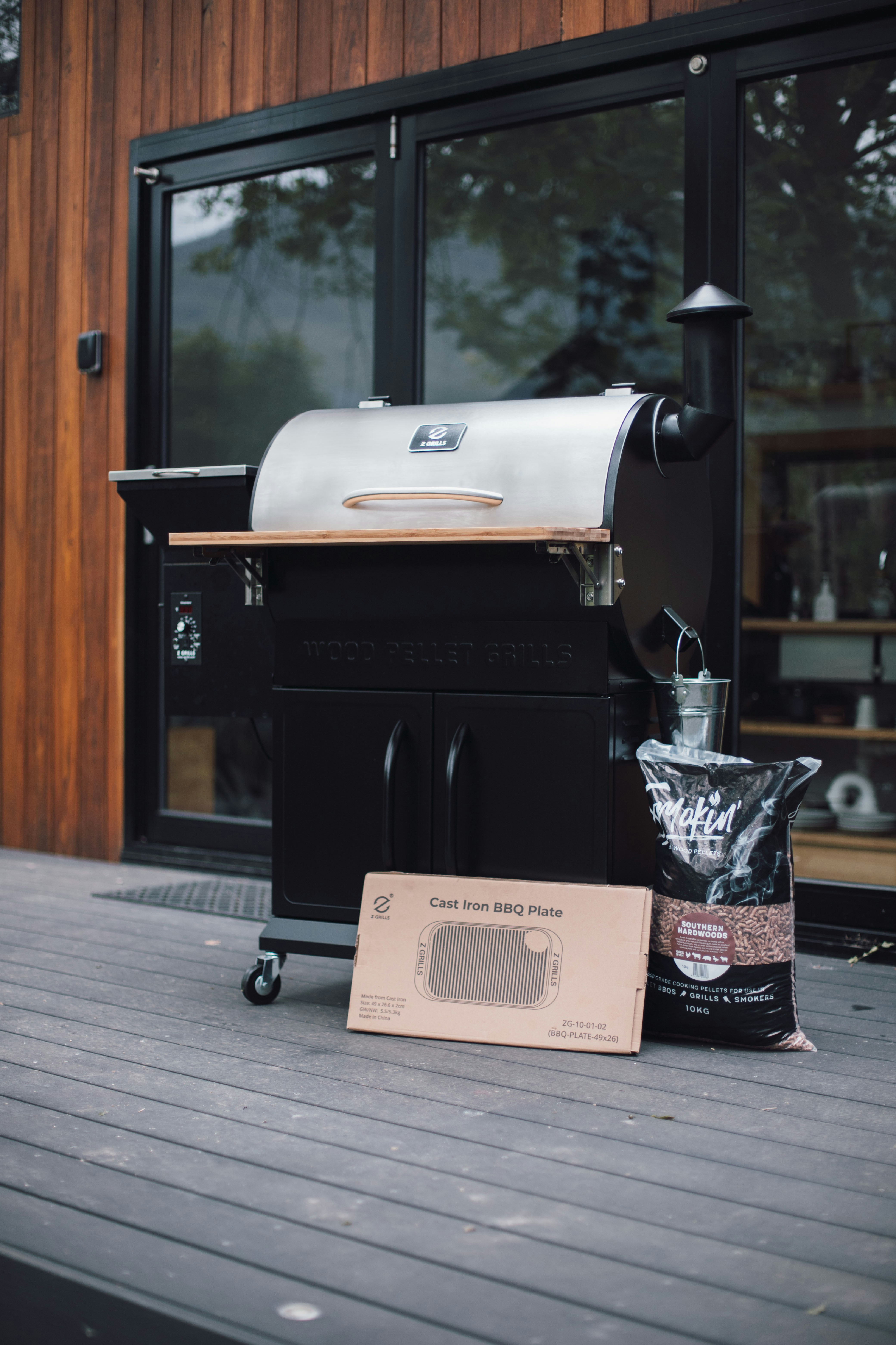 A grill with a bad of coal next to it on a terrace.