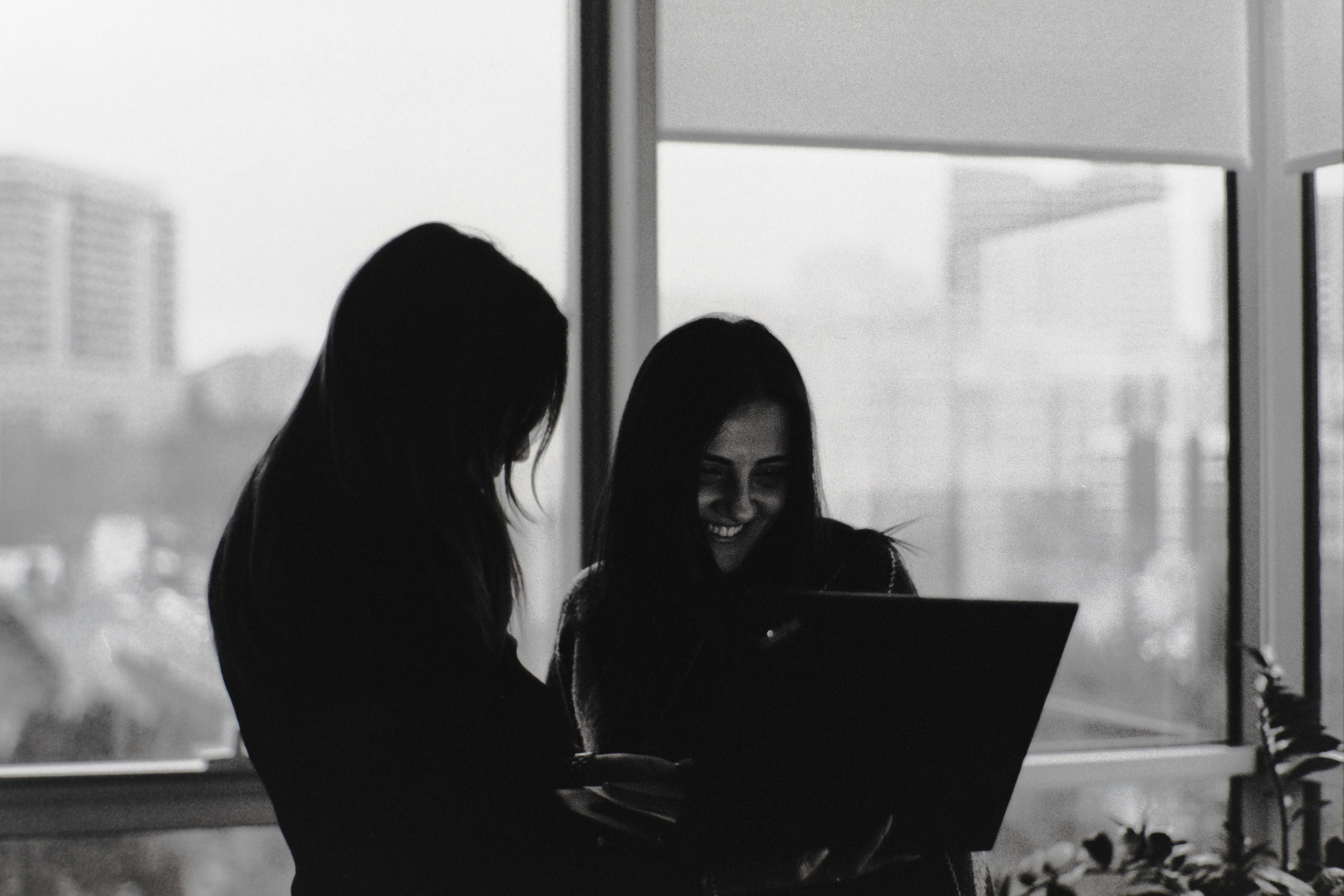 Two women looking at a laptop screen.