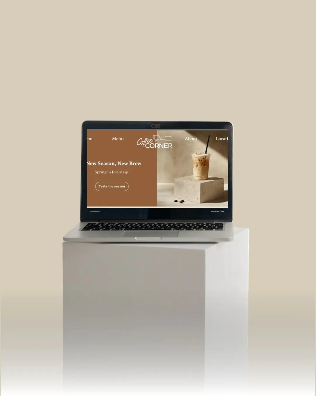 Computer der viser kaffe websitet, omgivet af beige baggrund