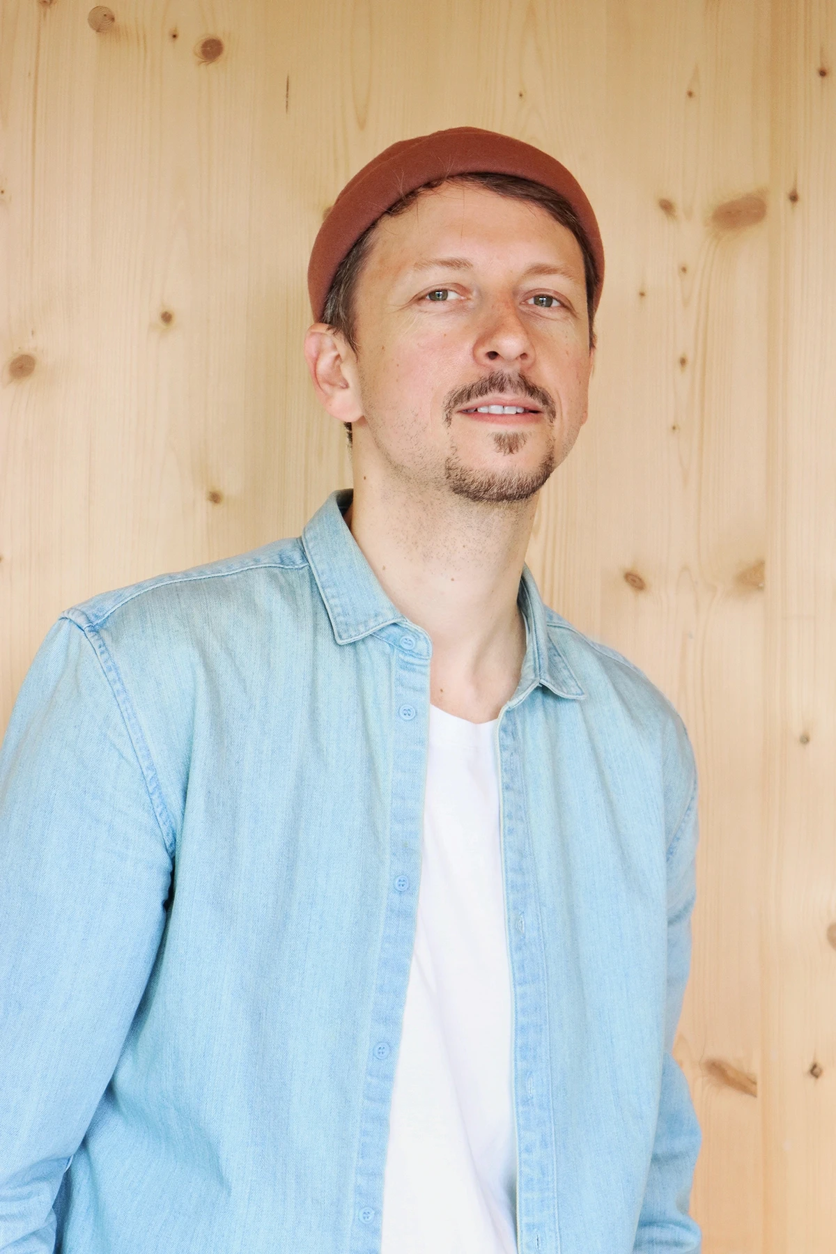 A view of a studio interior with modern decor, featuring large windows that offer a glimpse of lush greenery outside