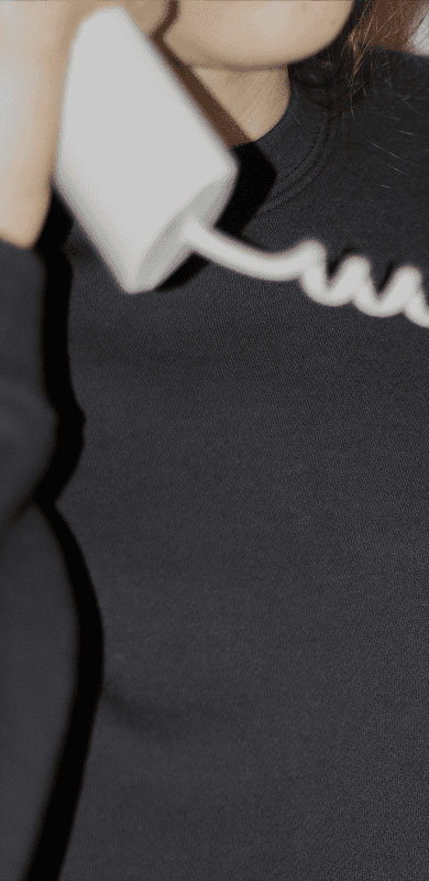 A close-up shot of a person in a black sweatshirt holding a white vintage-style telephone