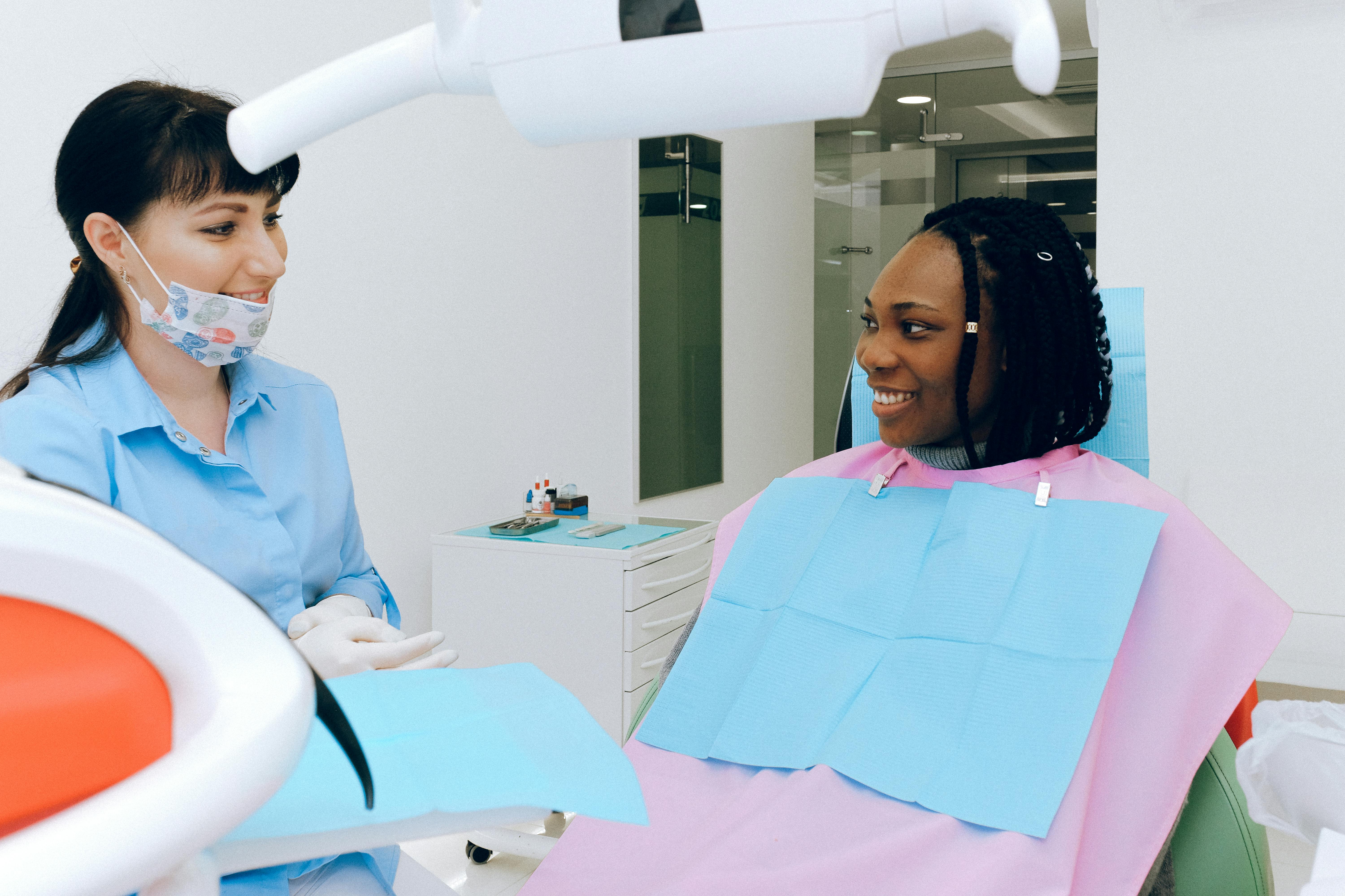dentist and patient talking and smiling in operatory