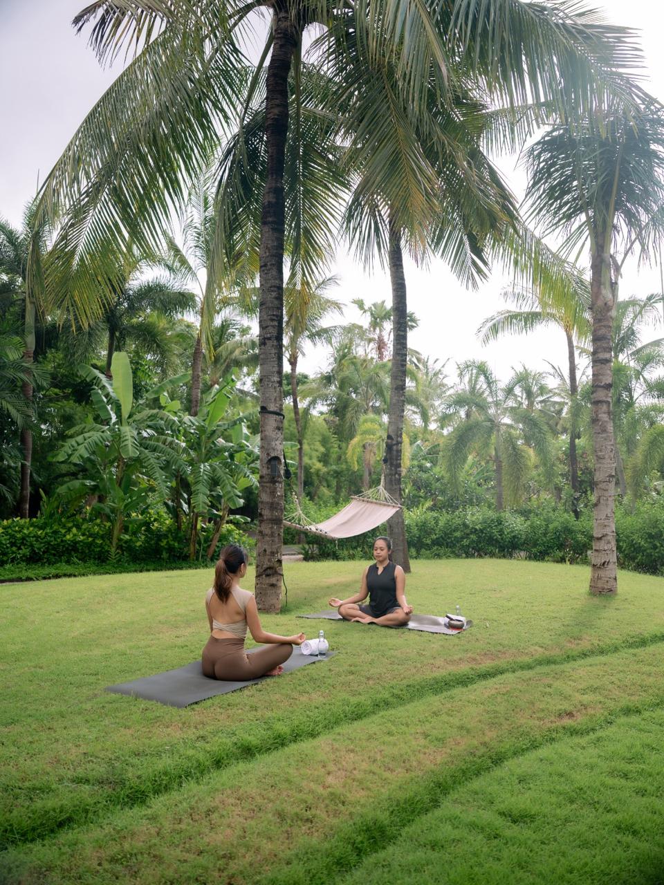 Man lying on a mat with eyes closed in a relaxation or meditation pose beside a burning incense bowl.