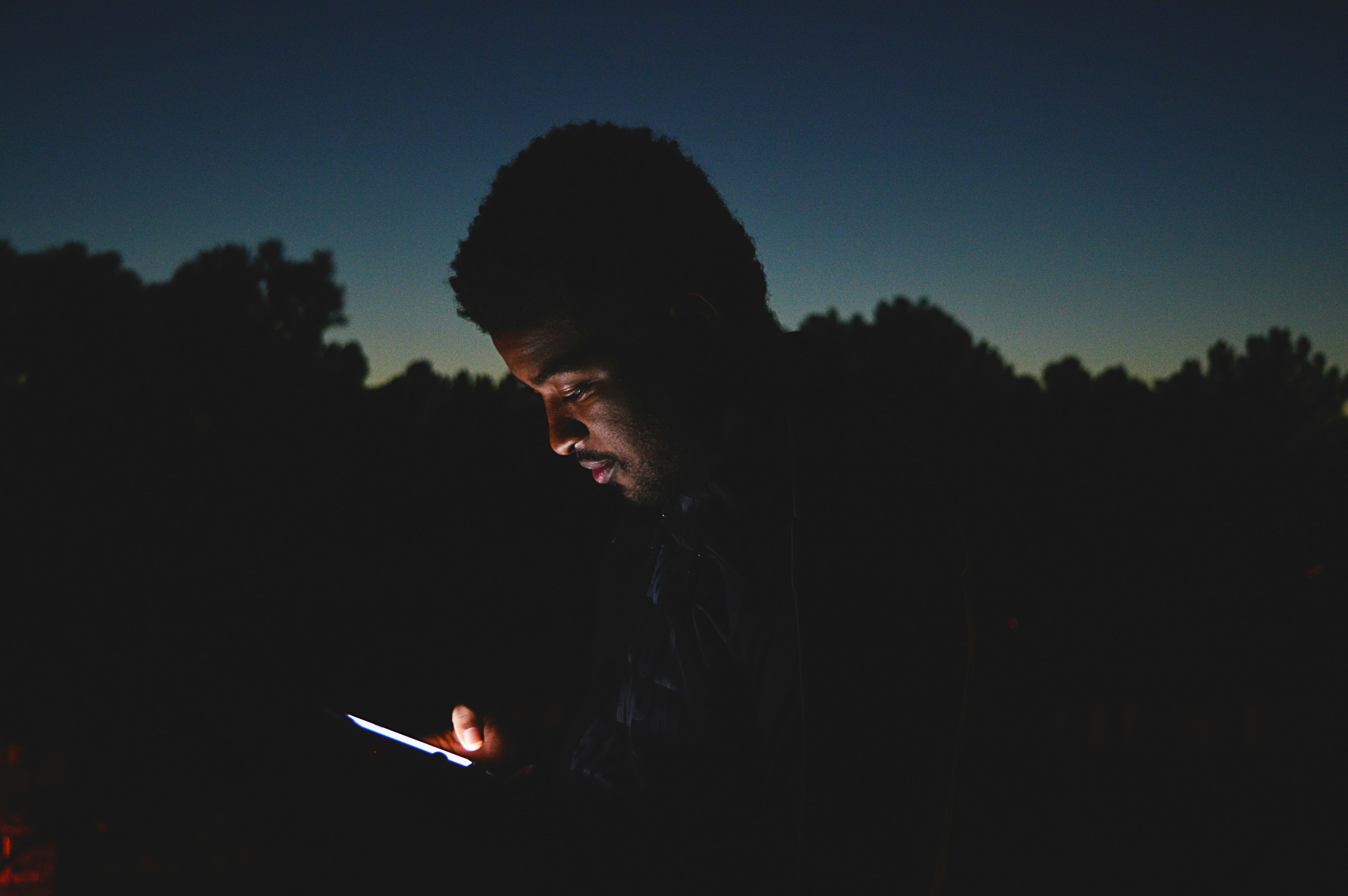 man looking at his phone in the dark - gmail filter not from domain