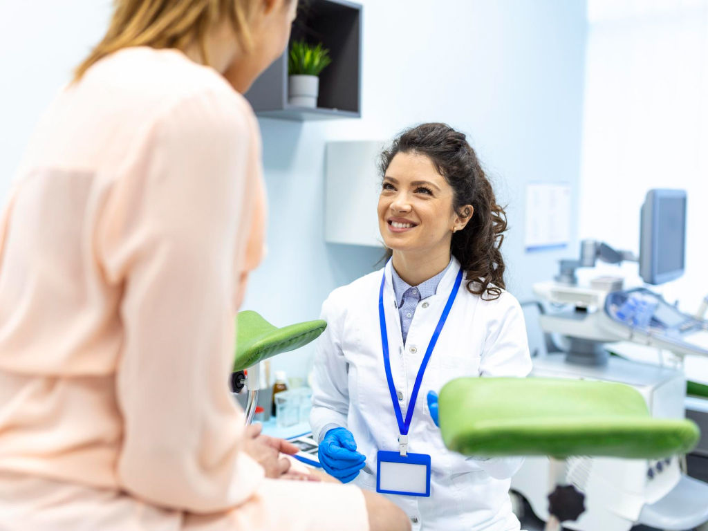 A woman conversing with her gynecologist while comfortably seated on a chair.