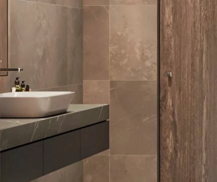 A sleek modern bathroom featuring a contemporary sink and a spacious shower area.