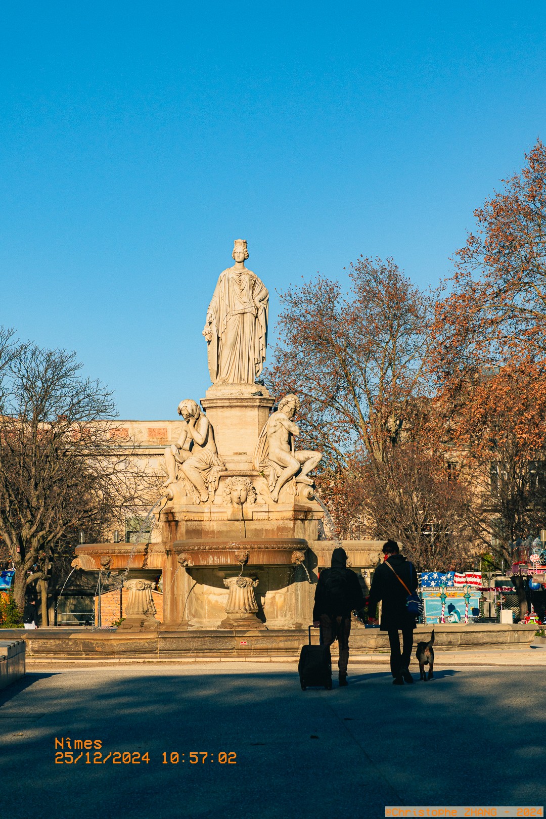 Statue monumentale de la Fontaine Pradier avec passants au premier plan.