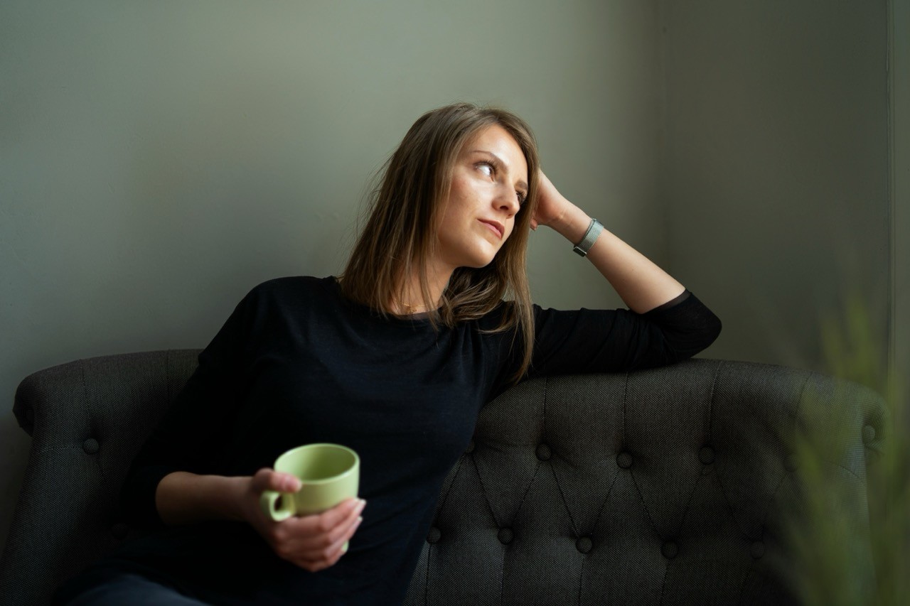 Person sitzt nachdenklich mit Kaffeetasse – innerer Stress entsteht oft unabhängig von äußeren Umständen