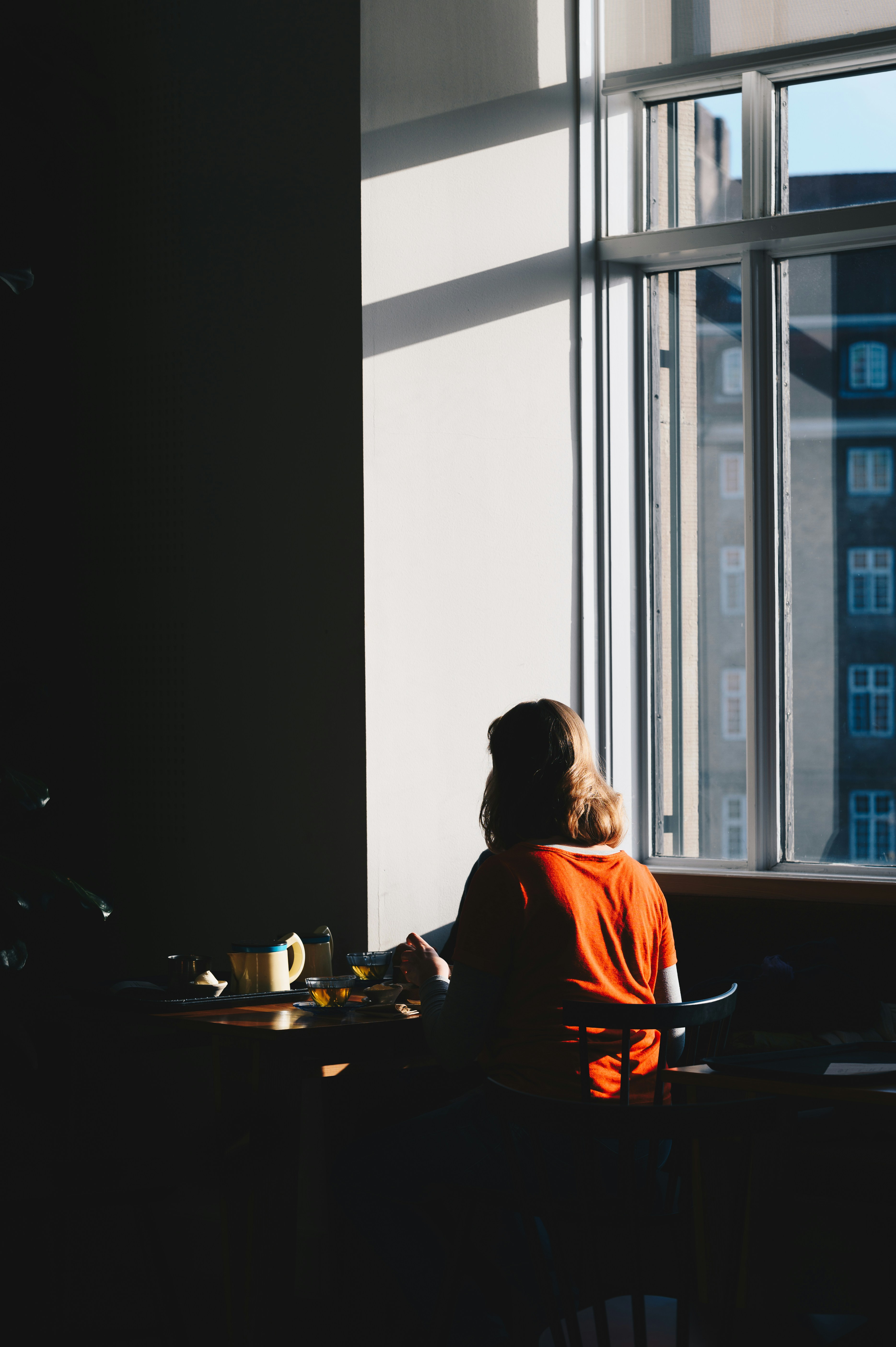woman sitting on chair next to window