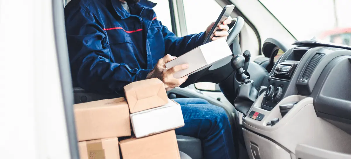 Delivery driver scanning packages inside a van
